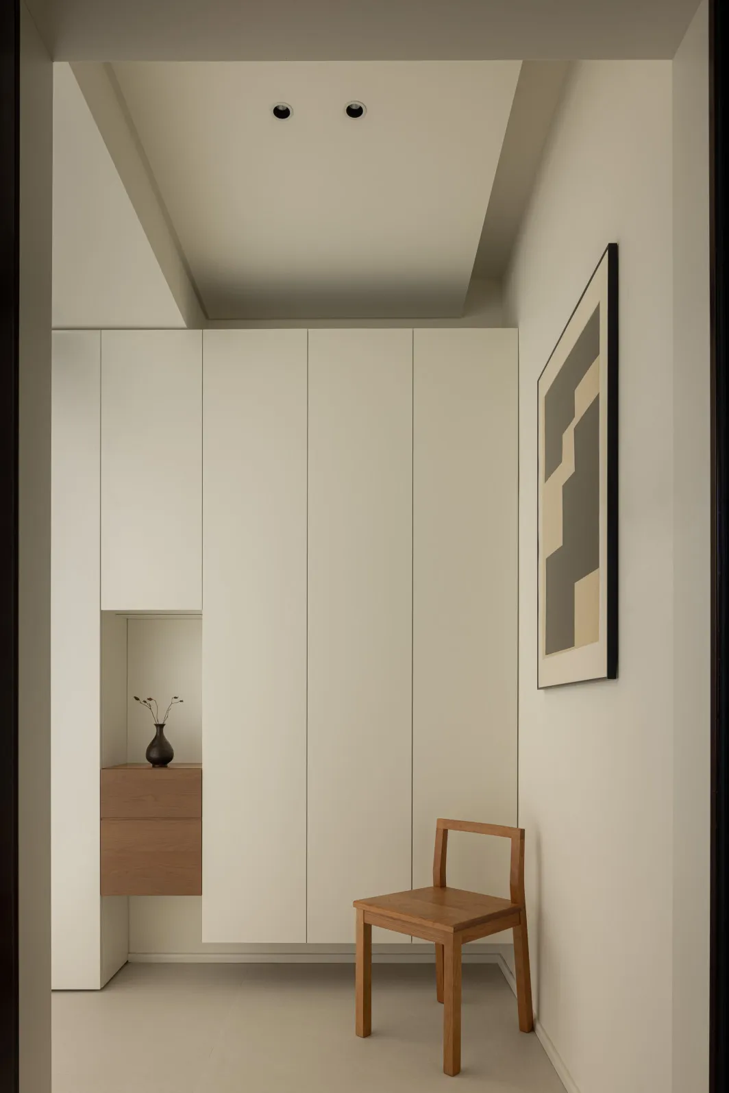 Minimalist living room with neutral tones and a wooden chair.