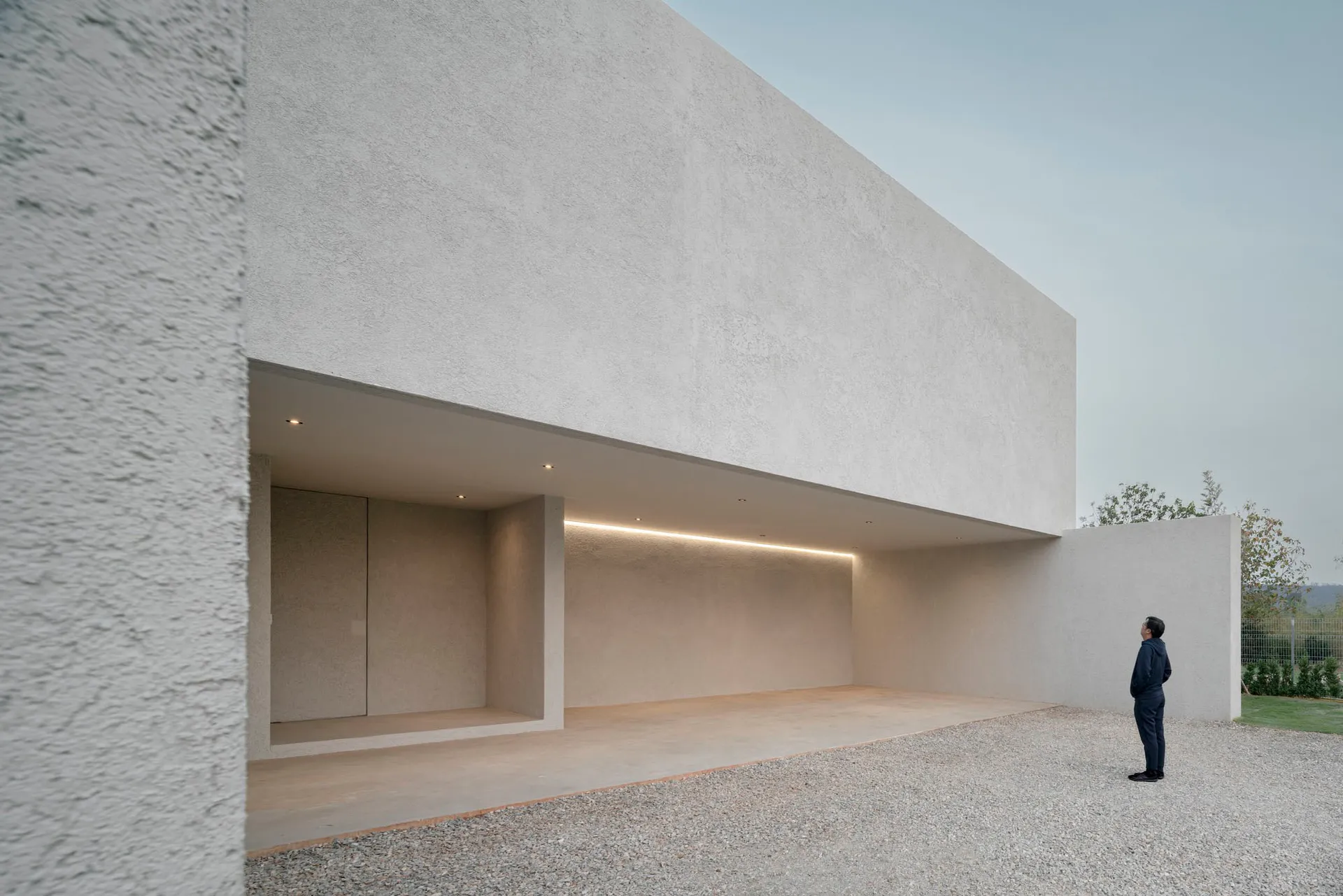 Modern residential architecture featuring a minimalist design with concrete walls and a spacious open layout.