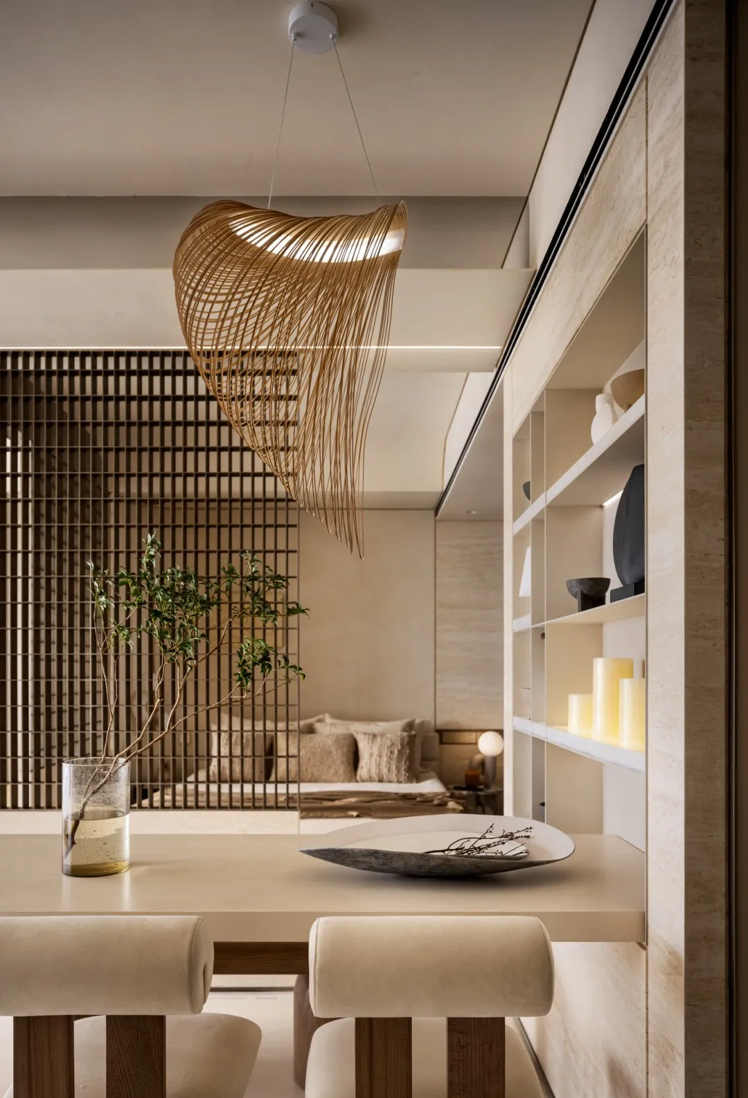 Minimalist dining room featuring concrete and wooden elements, with a modern chandelier and decorative elements.