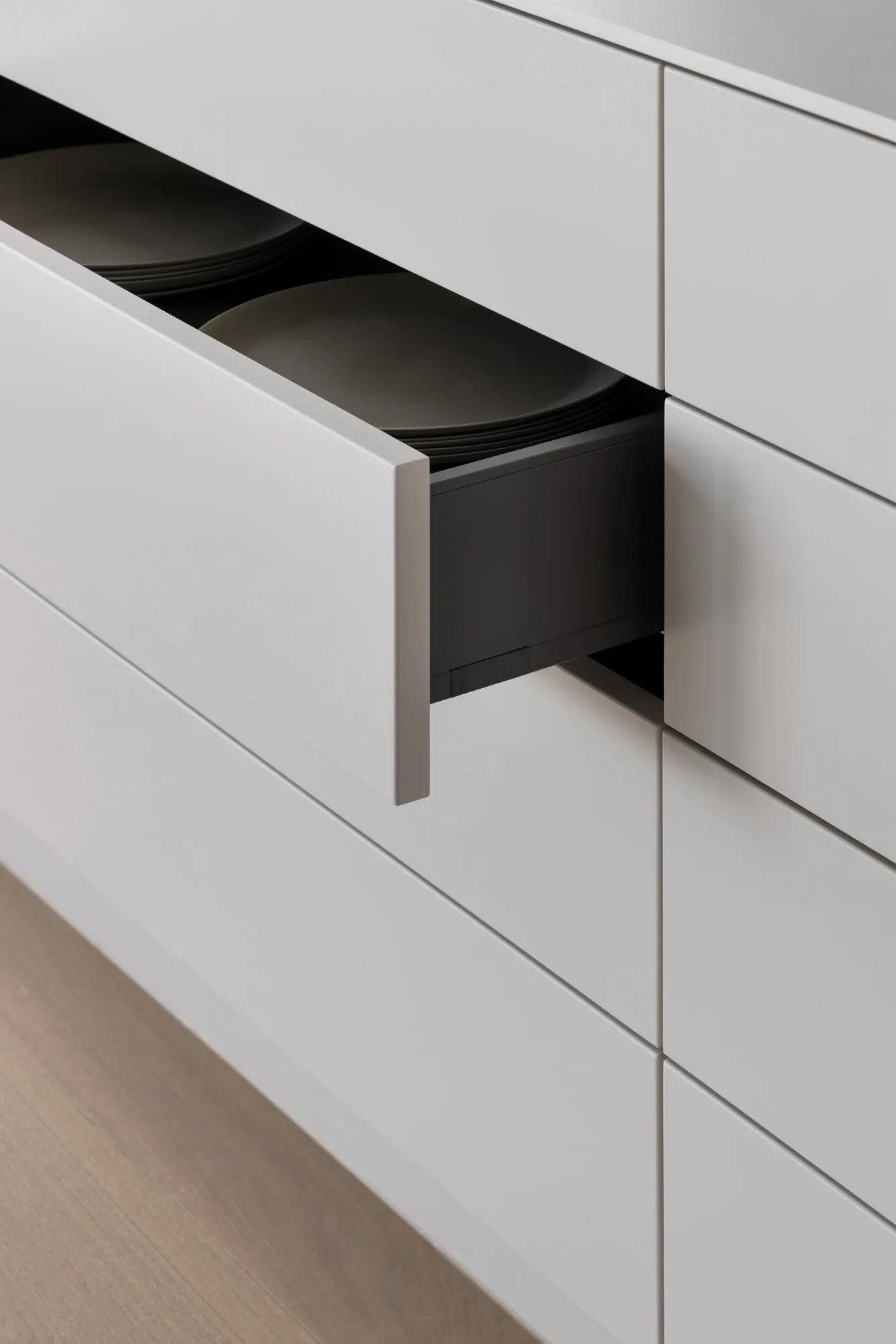A minimalist white cabinet with a modern design, showcasing clean lines and sleek surfaces.