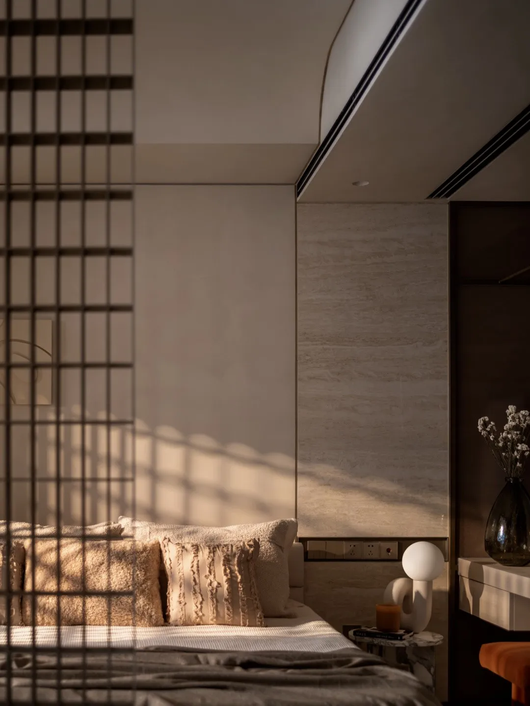 Modern bedroom with neutral-toned materials and cozy bedding.