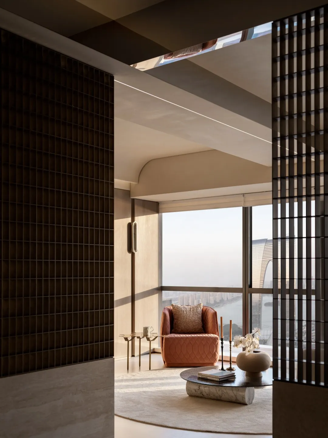 Modern living room with high ceiling, featuring contemporary furniture and cityscape view.