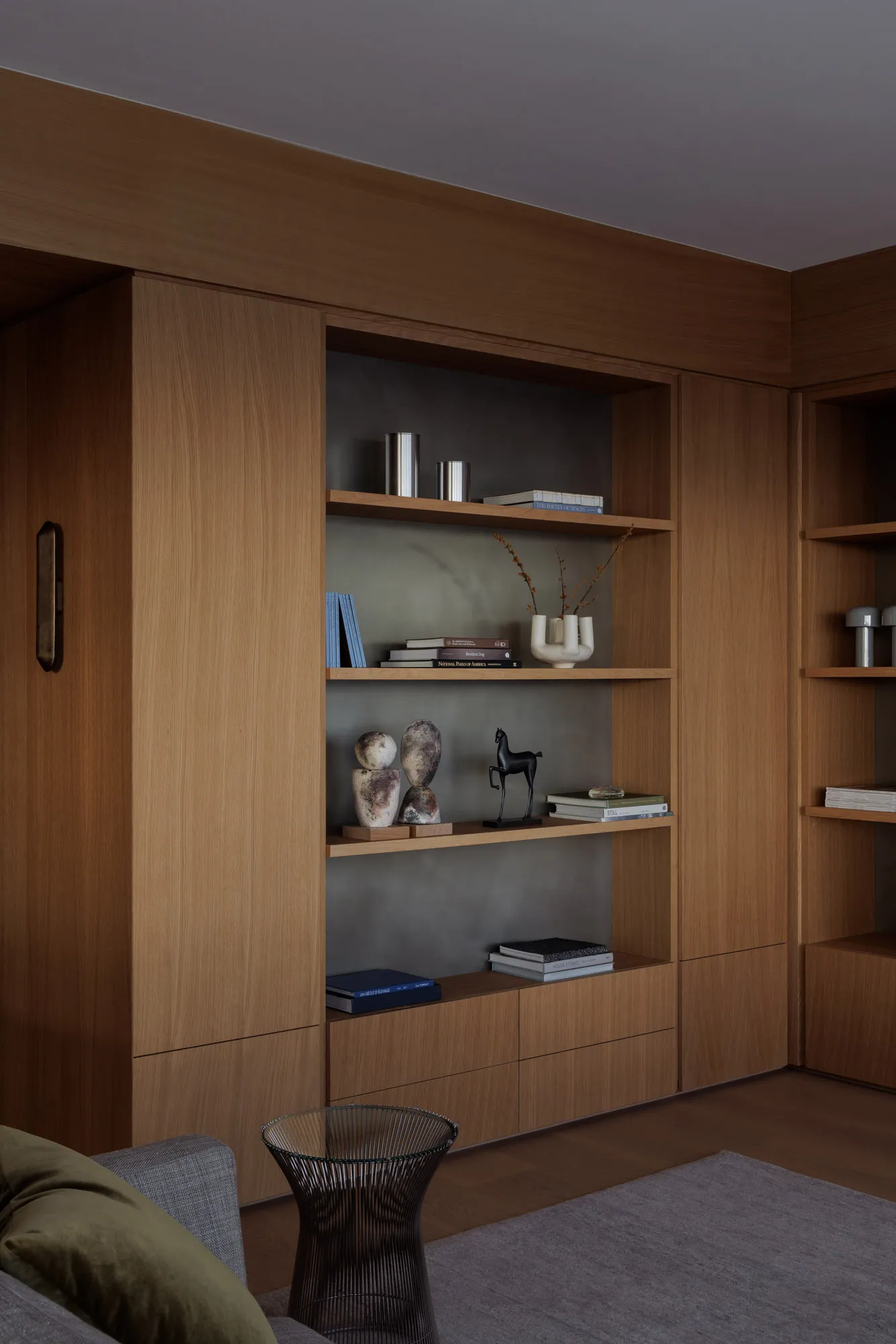 A modern residential interior with wooden shelves and concrete accents.