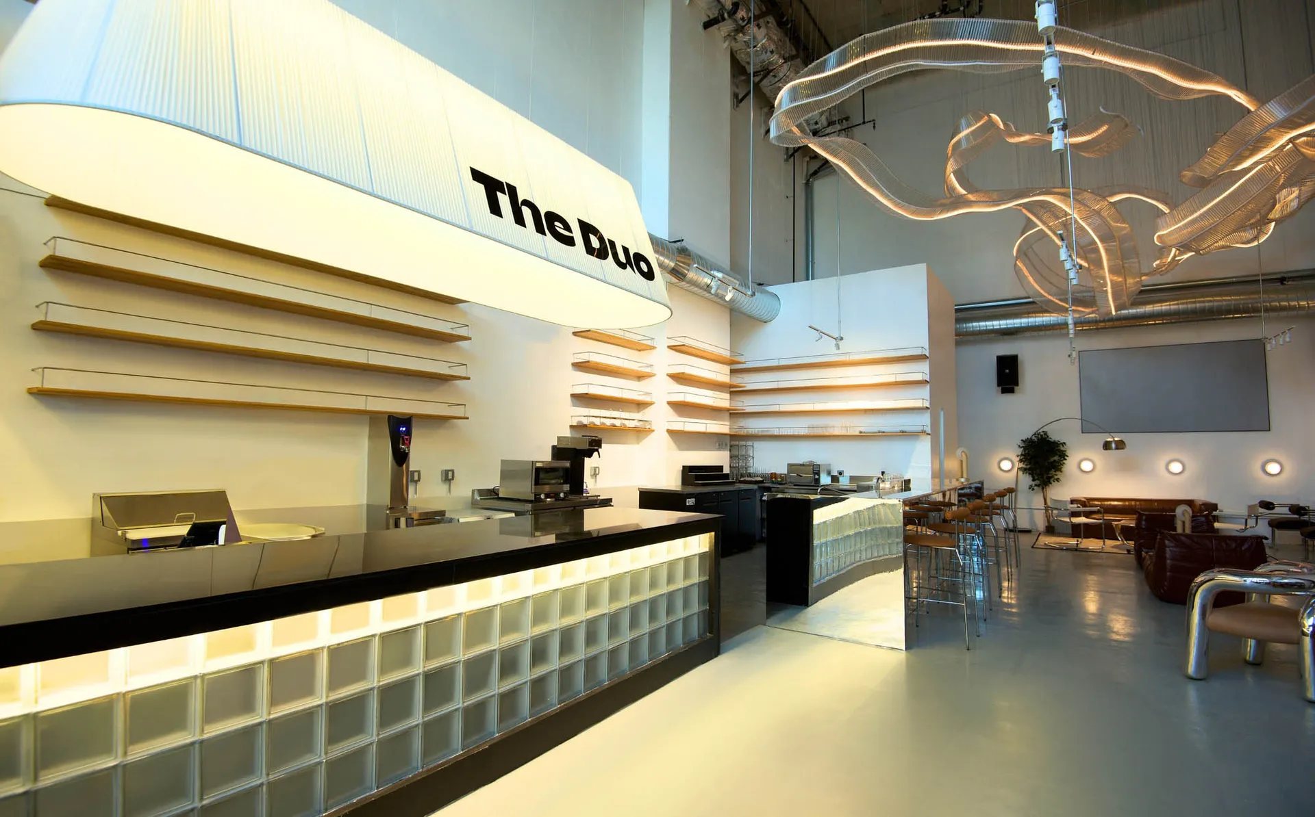 A minimalist coffee shop bar with modern design elements like metal and glass.