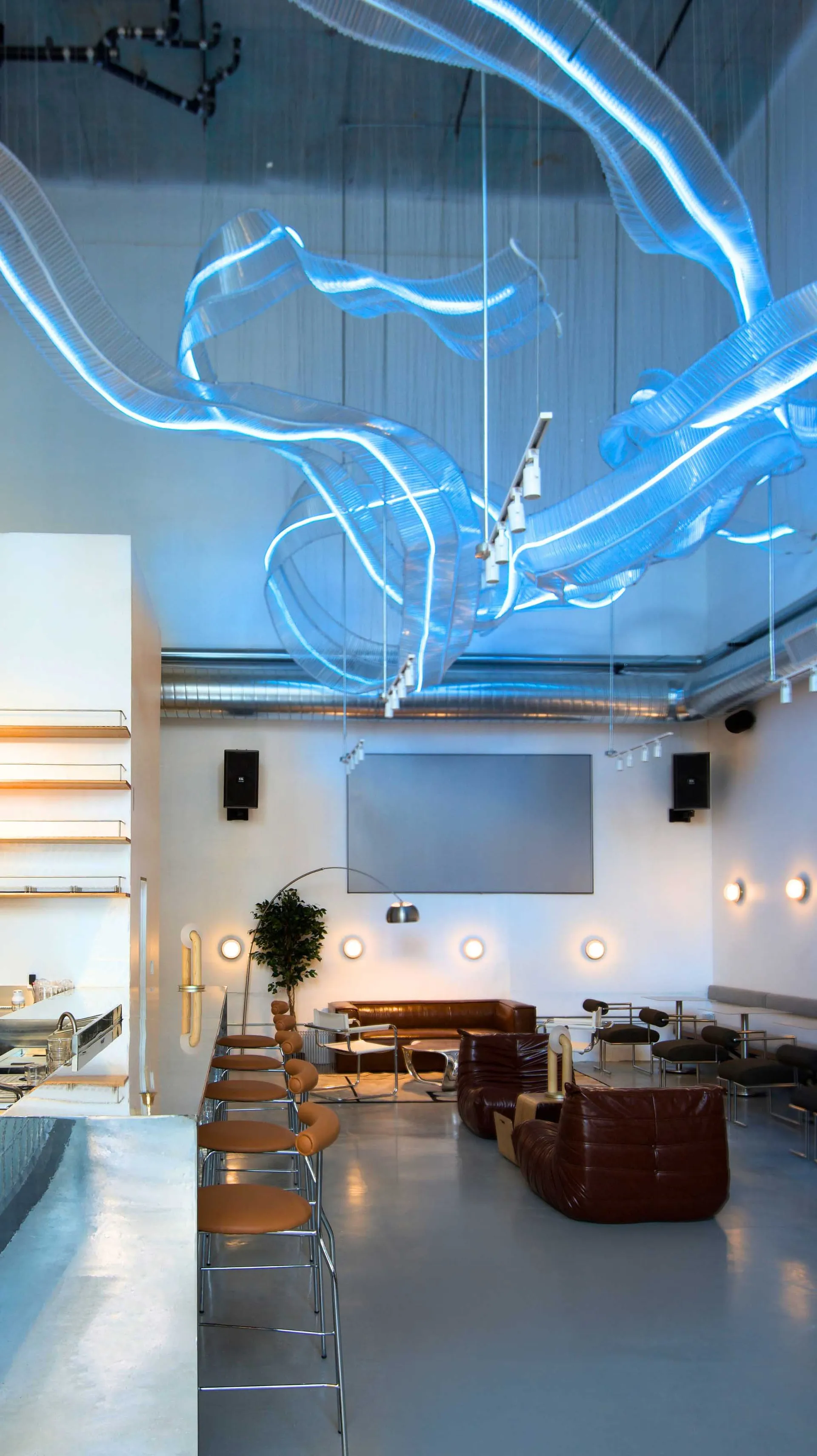 Modern interior design of a coffee house bar with glass elements and concrete floor.