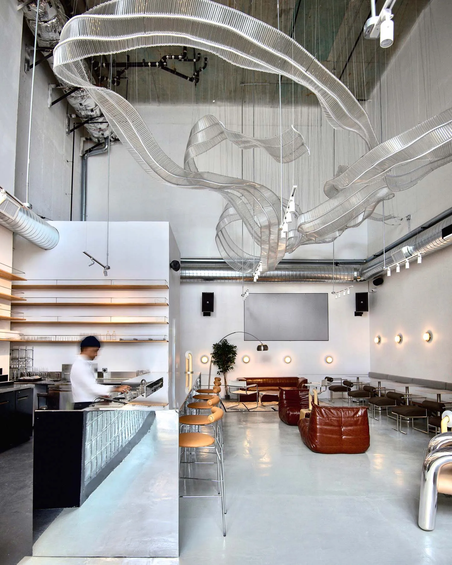 A modern restaurant with a metal and glass ceiling art installation
