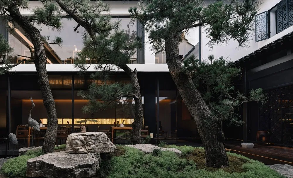 An elegant, modern restaurant interior with concrete flooring and a minimalist design.