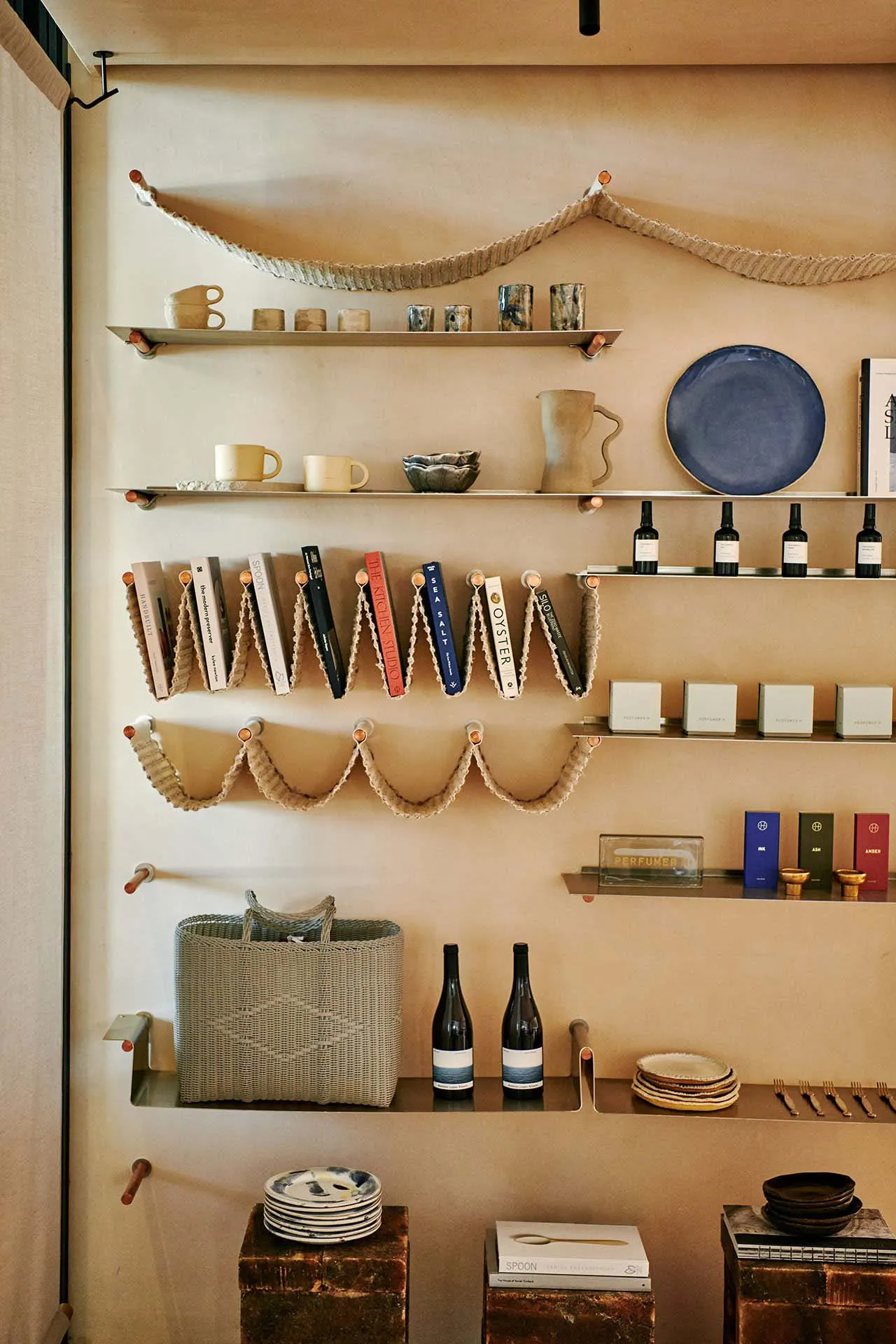 Retail interior with metal shelves displaying ceramic items and books.