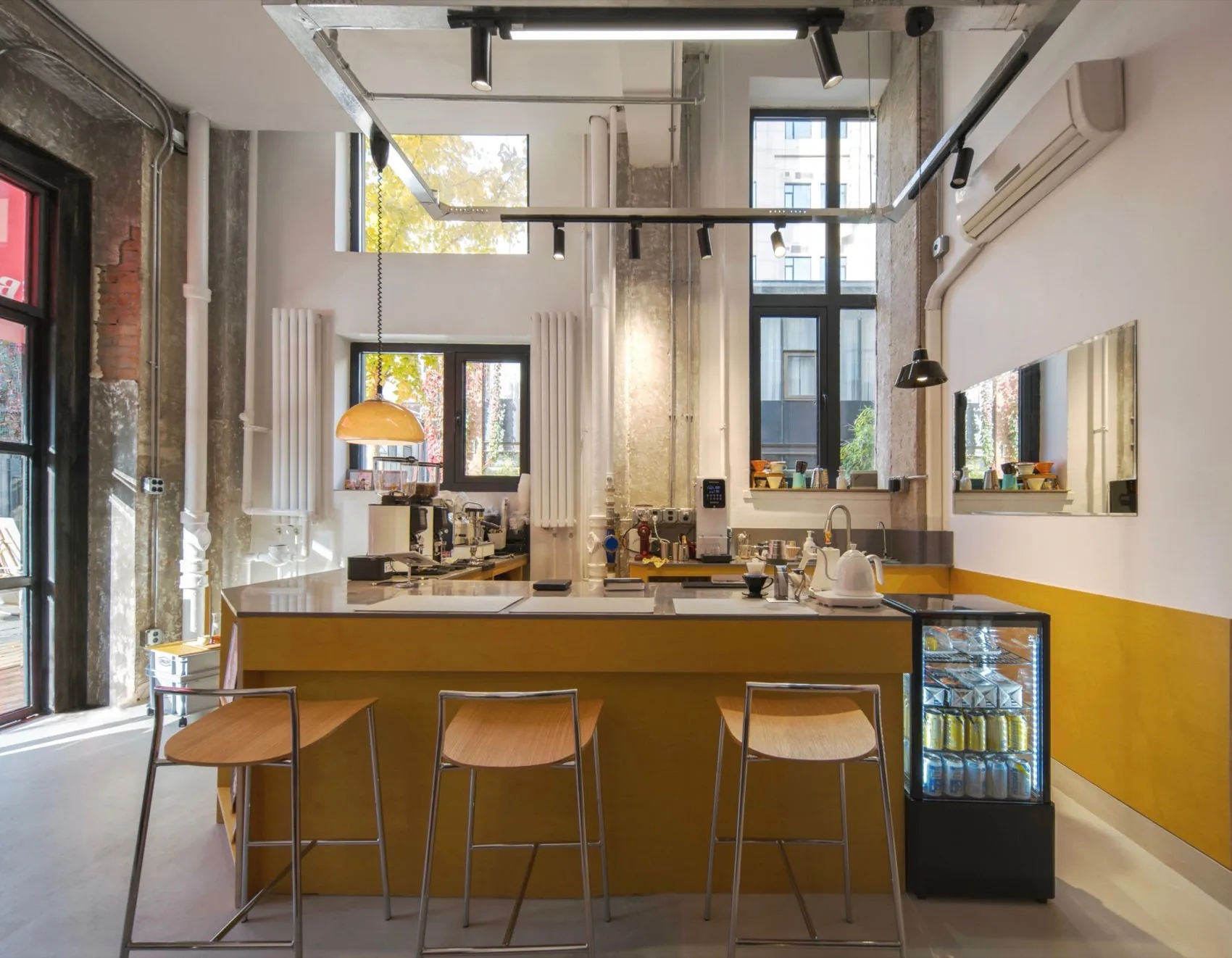 Industrial style cafe bar with wooden seating and concrete walls and floor