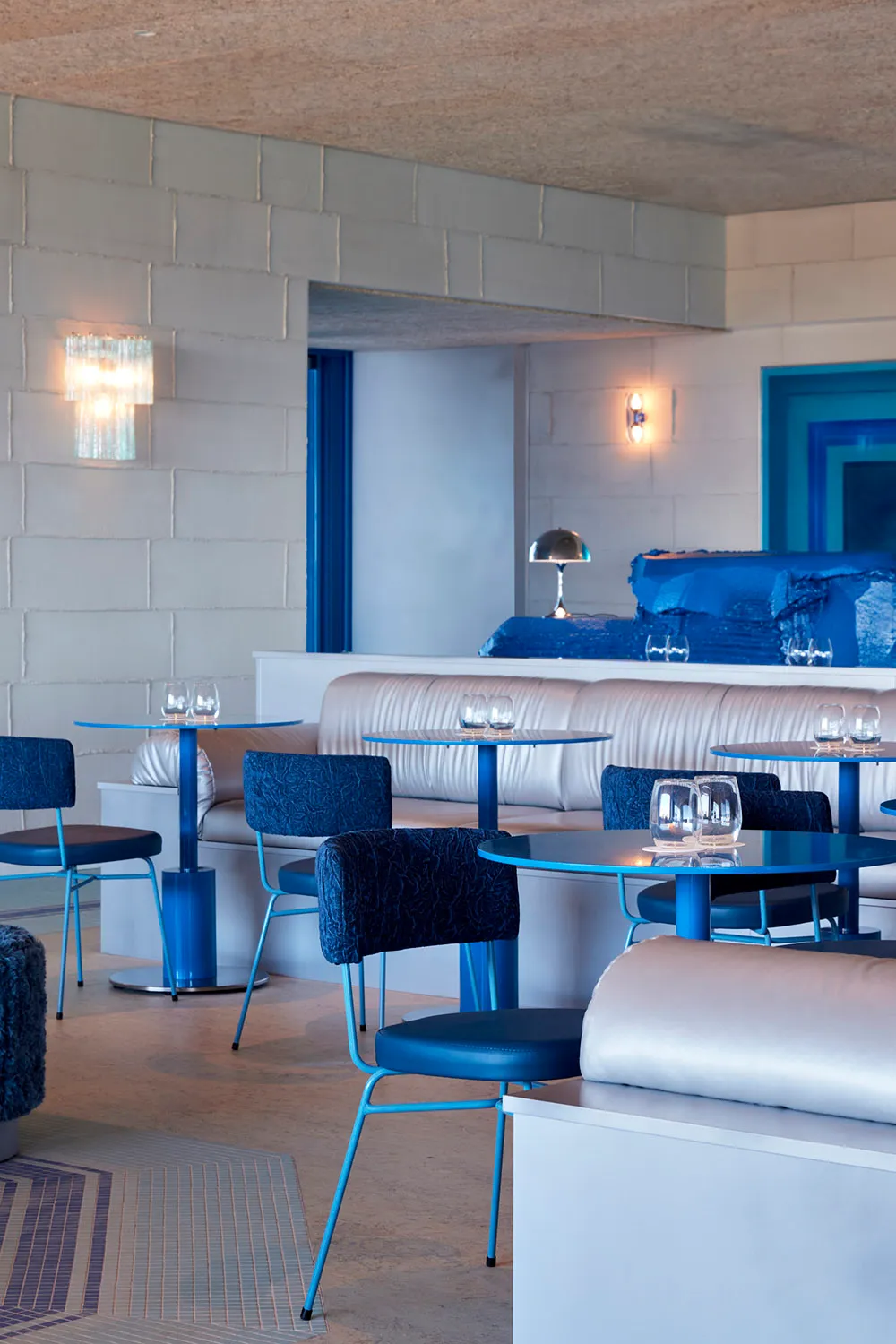Modern restaurant interior with blue accents and fixtures.