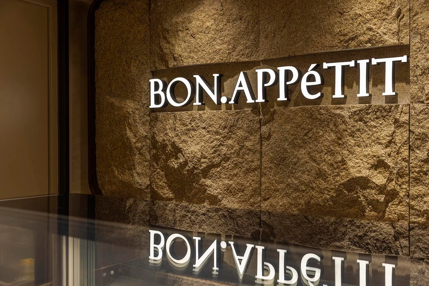 工業設計金屬招牌，上面寫著「BON.APPETIT」