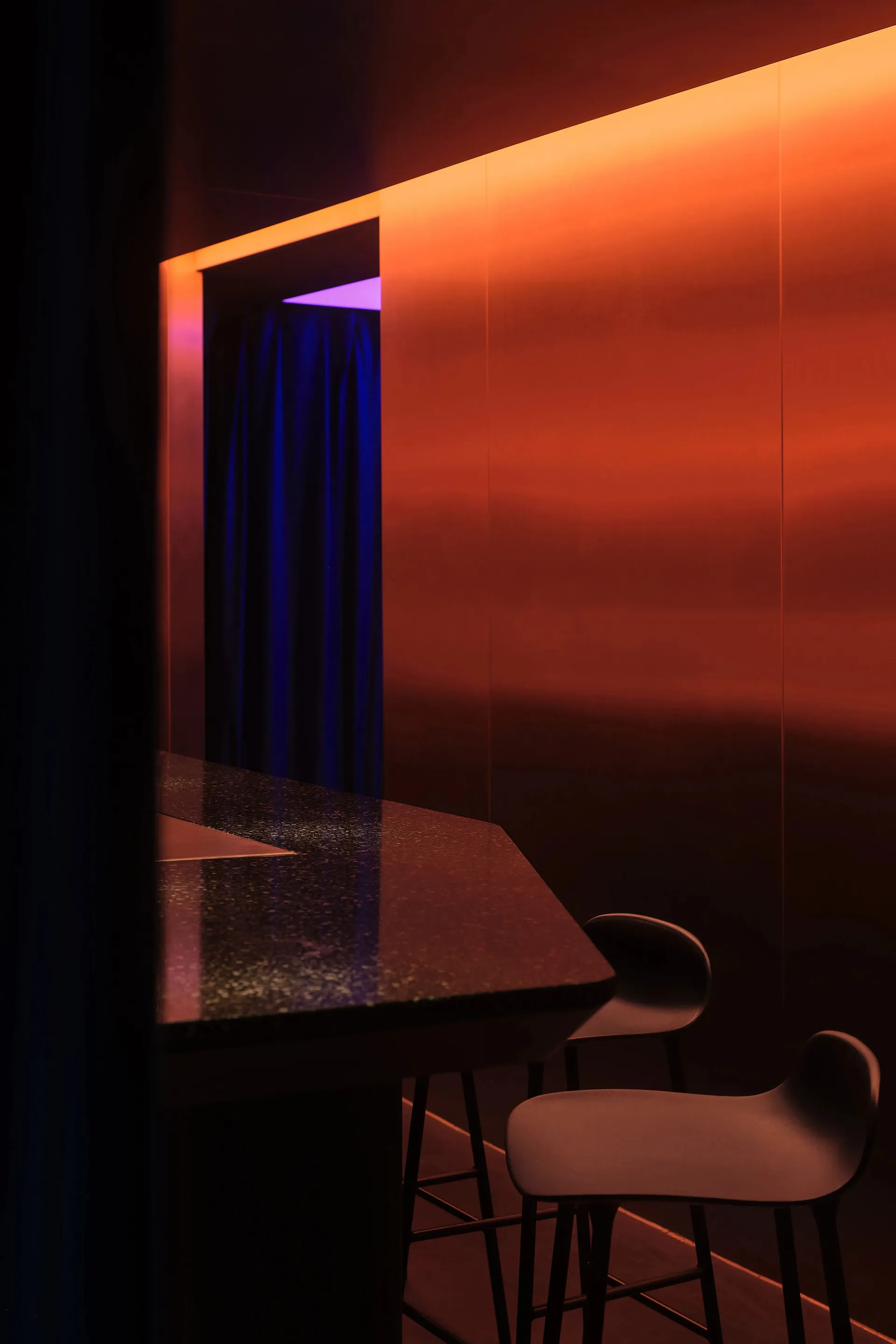 A minimalist black bar stool with a sleek design and metallic texture.
