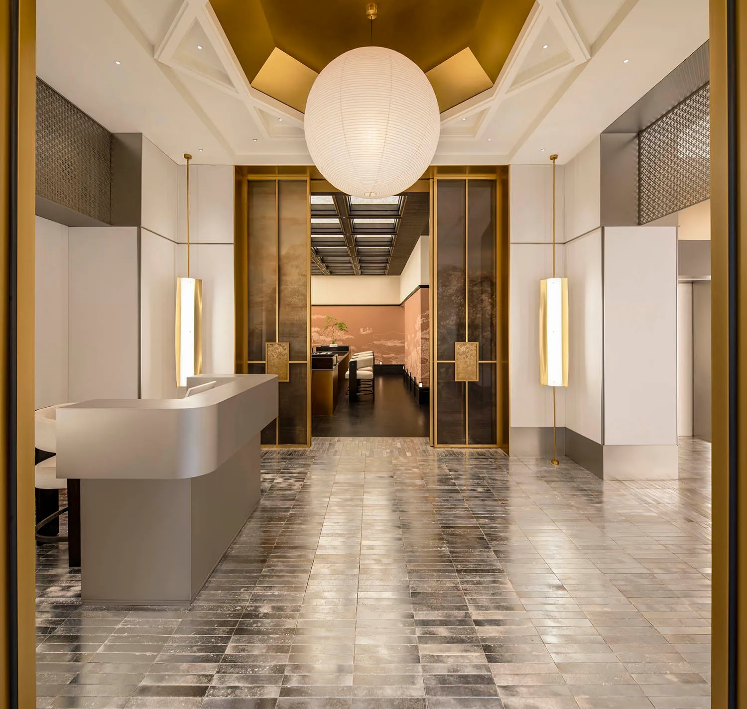 A modern lobby interior with marble floors and a reception desk.