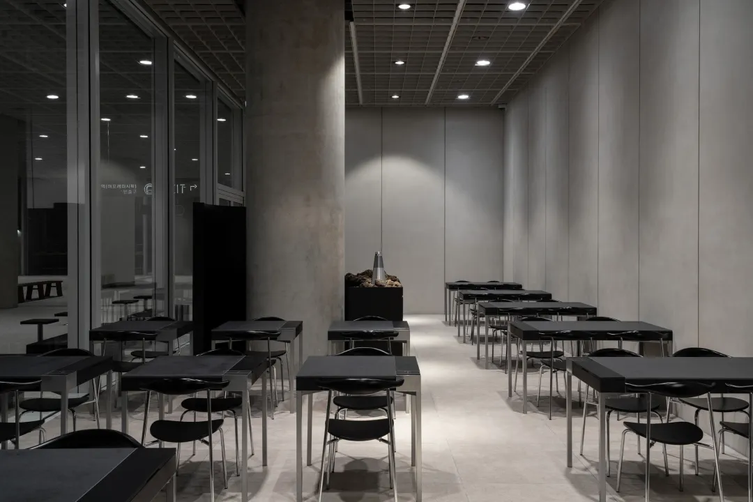 簡約風格的餐廳,擁有混凝土牆面與金屬桌椅。