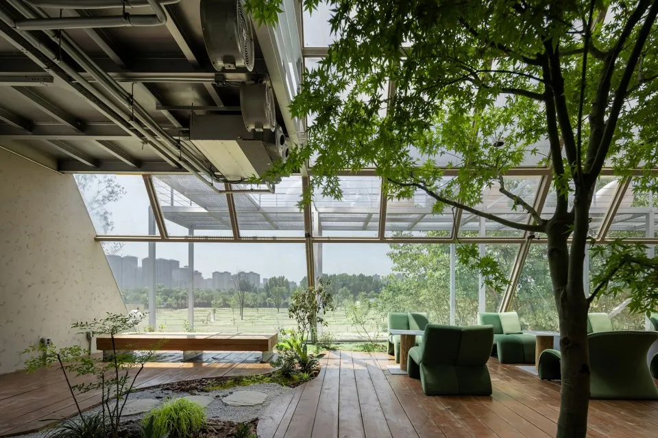 A modern indoor space with glass walls, wooden flooring, and metal accents.
