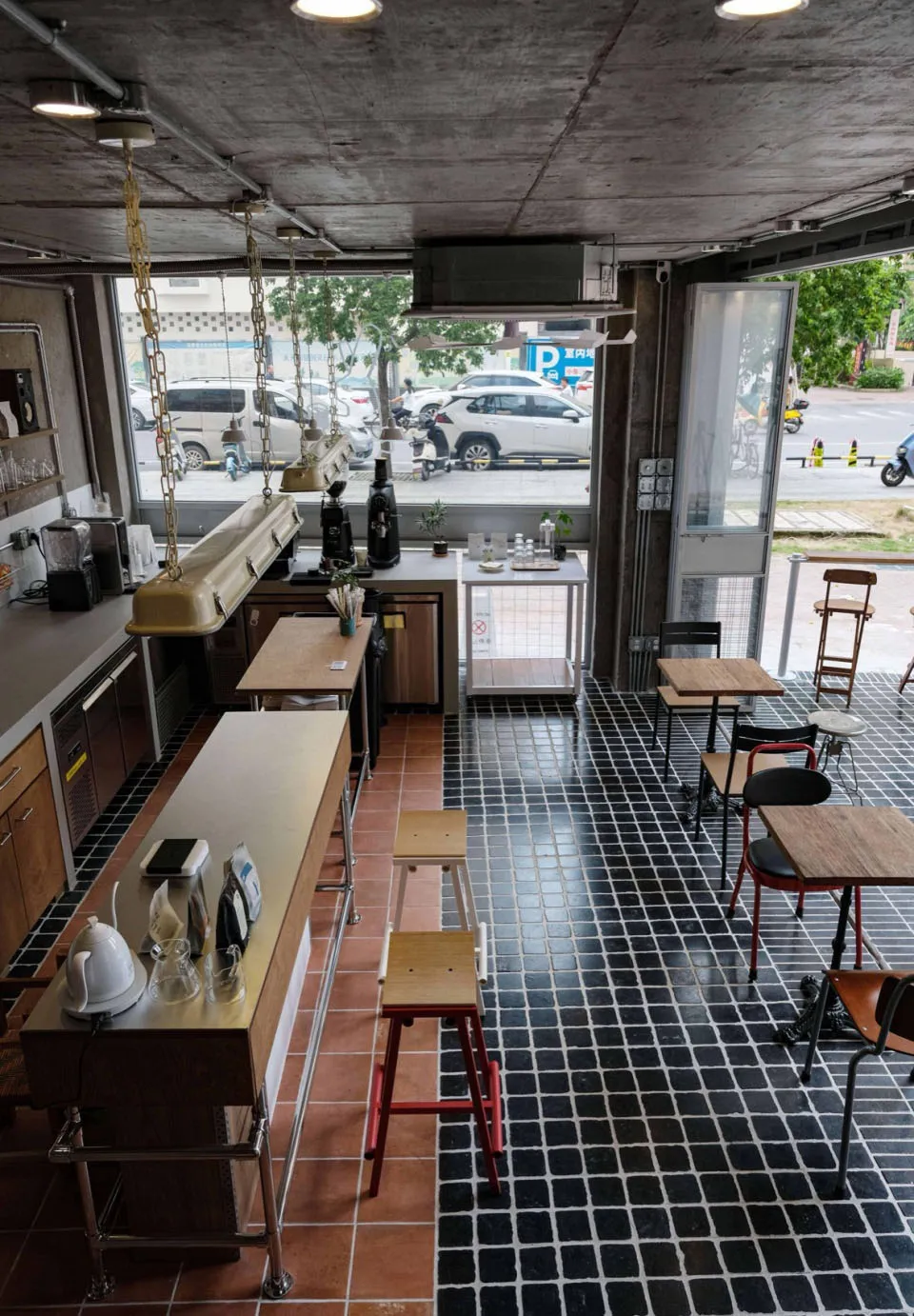 An industrial-style coffee shop with a tile floor and concrete walls.