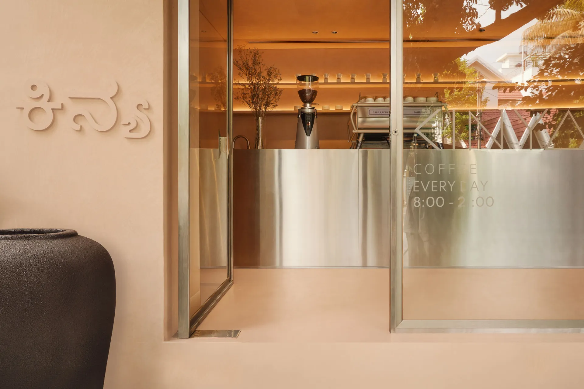 A minimalist coffee shop with a glass exterior, showcasing sleek and modern design elements.