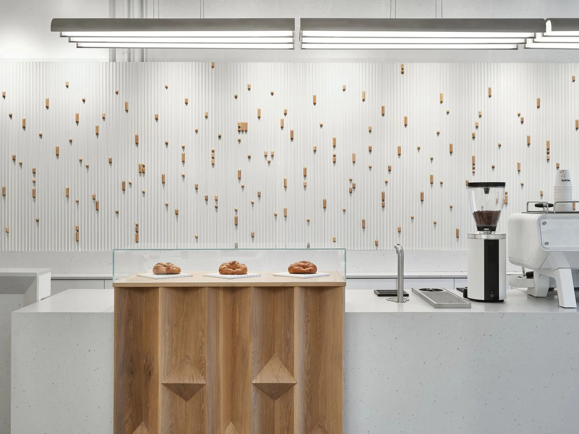 A minimalist restaurant counter featuring wood and concrete materials.