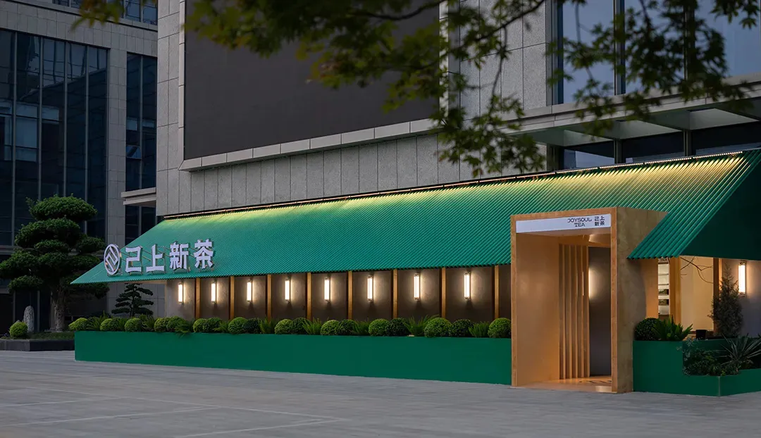 現代餐廳外觀,搭配綠色金屬屋頂與發光招牌。