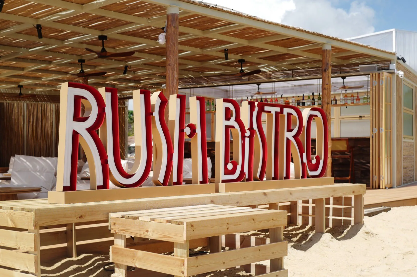 木質海灘酒吧，掛著大型「RUSH BISTRO」紅色招牌。