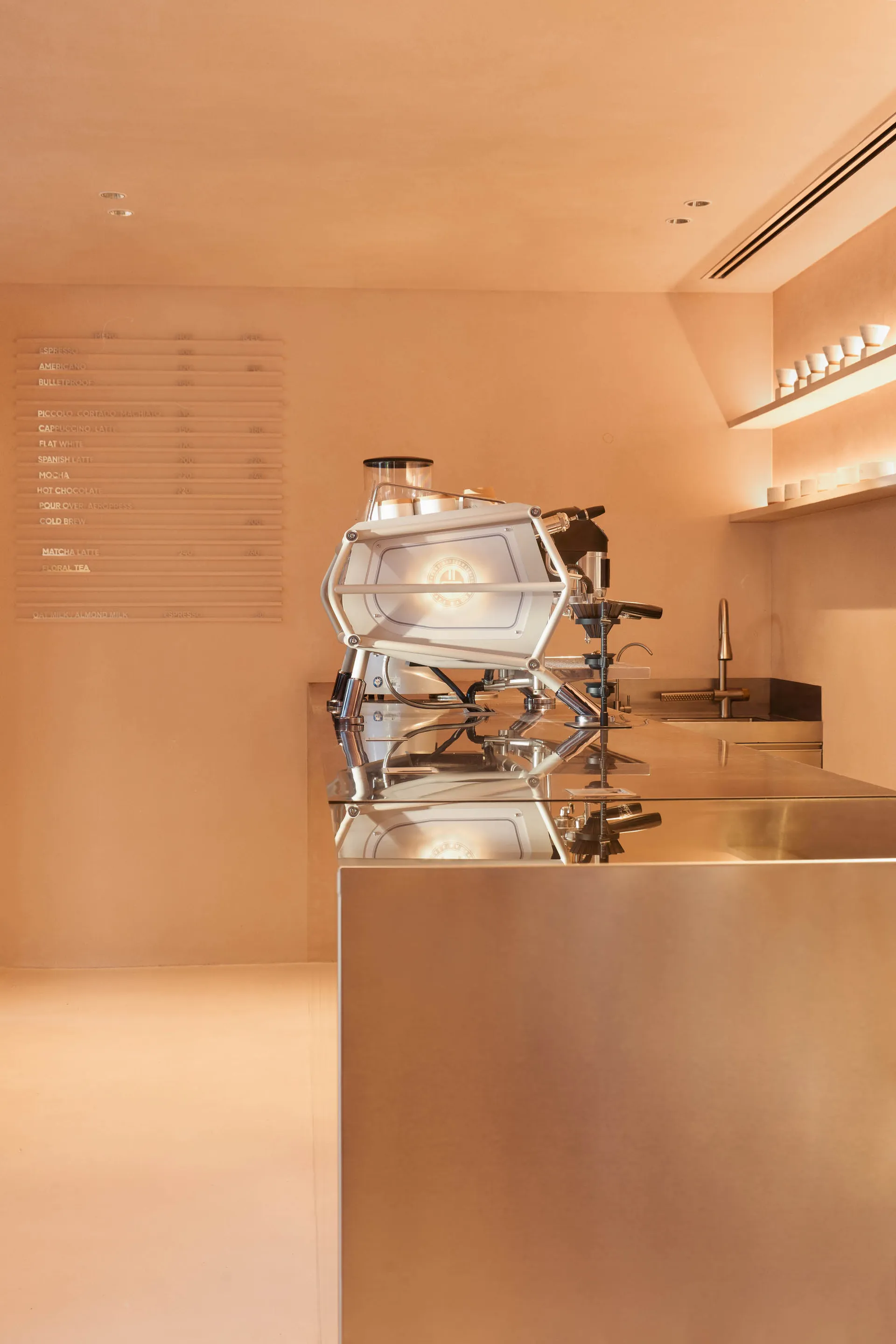 Modern coffee shop interior with a steel-clad counter top and minimalist design.