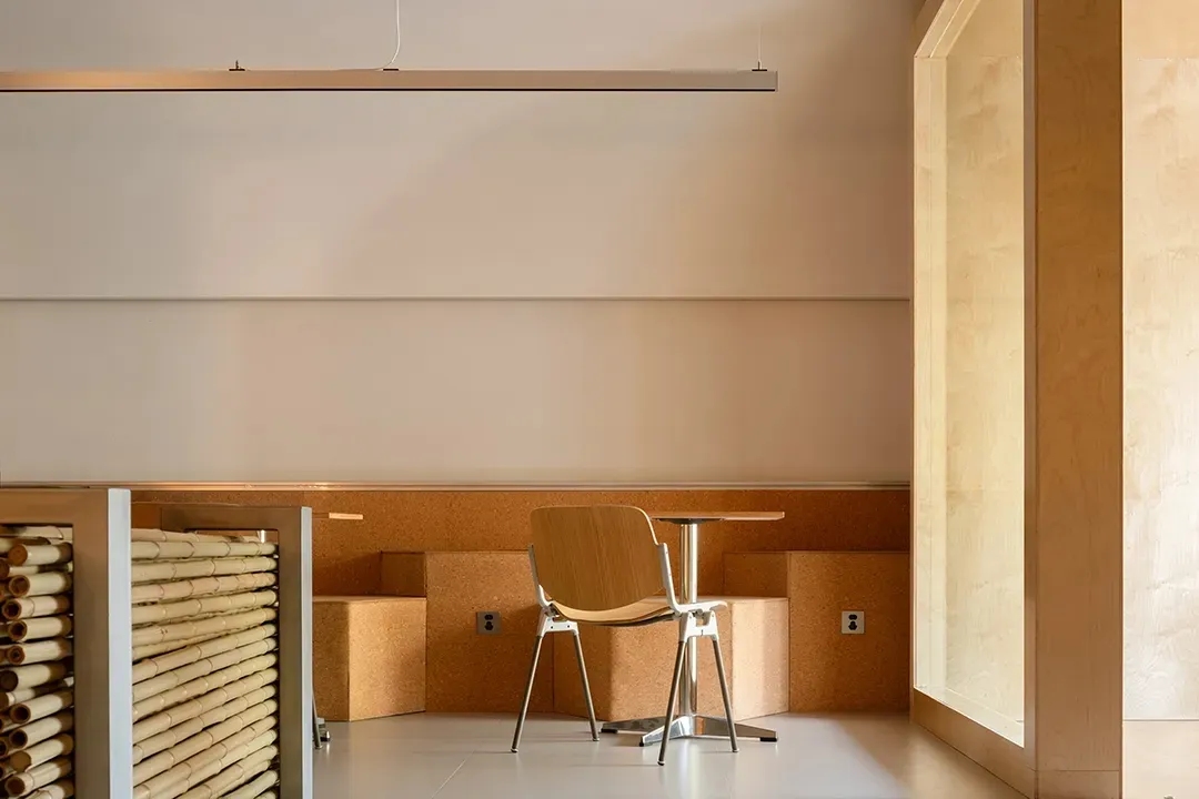 A minimalist interior space featuring cork, wood, and metal materials.