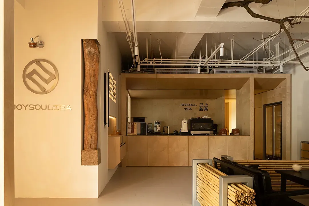 Seating area with industrial-style tables, metal chairs, and exposed wood and concrete surfaces.
