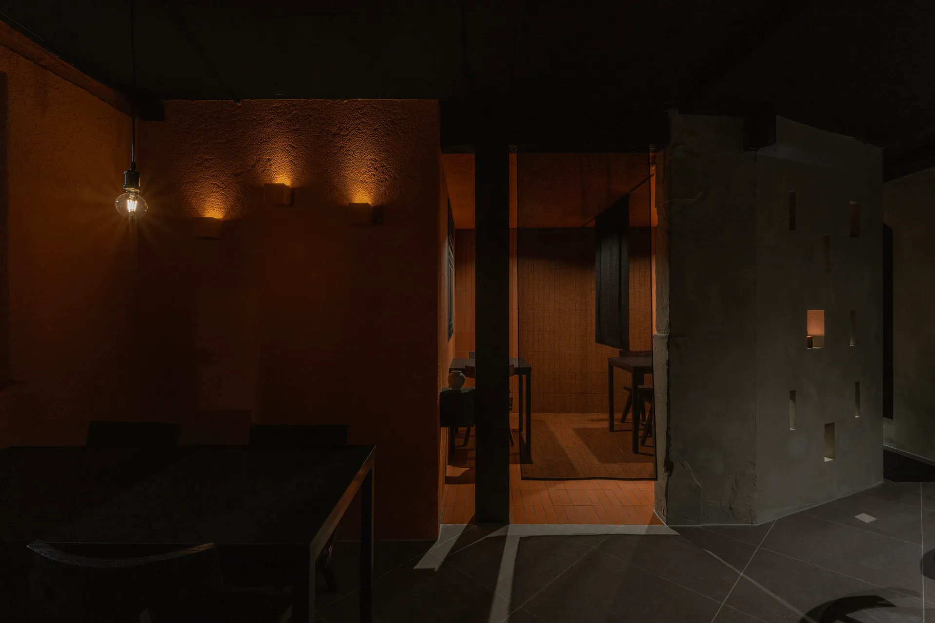 A minimalist indoor space with concrete walls and floor.