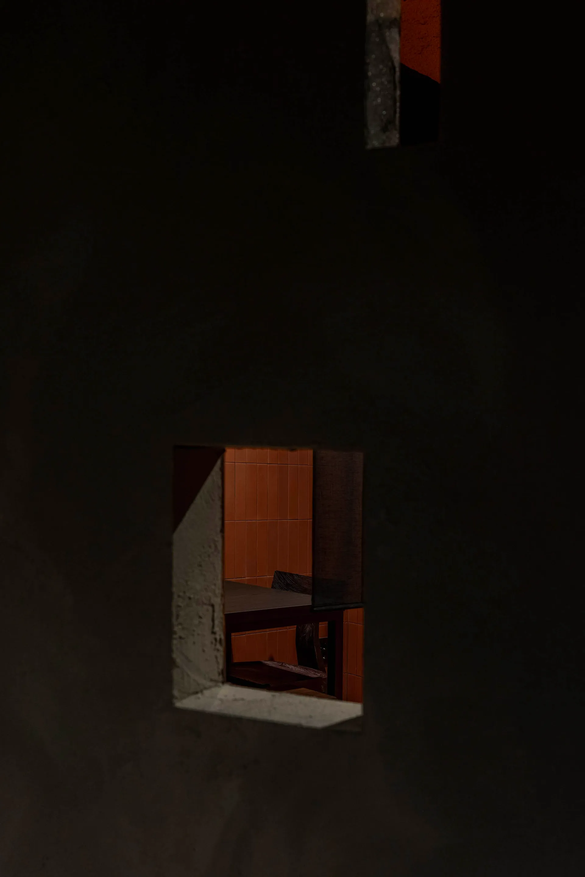 A minimalist interior space with a concrete wall and floor