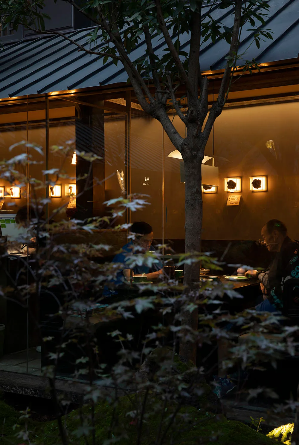 People dining in a restaurant with glass window frames