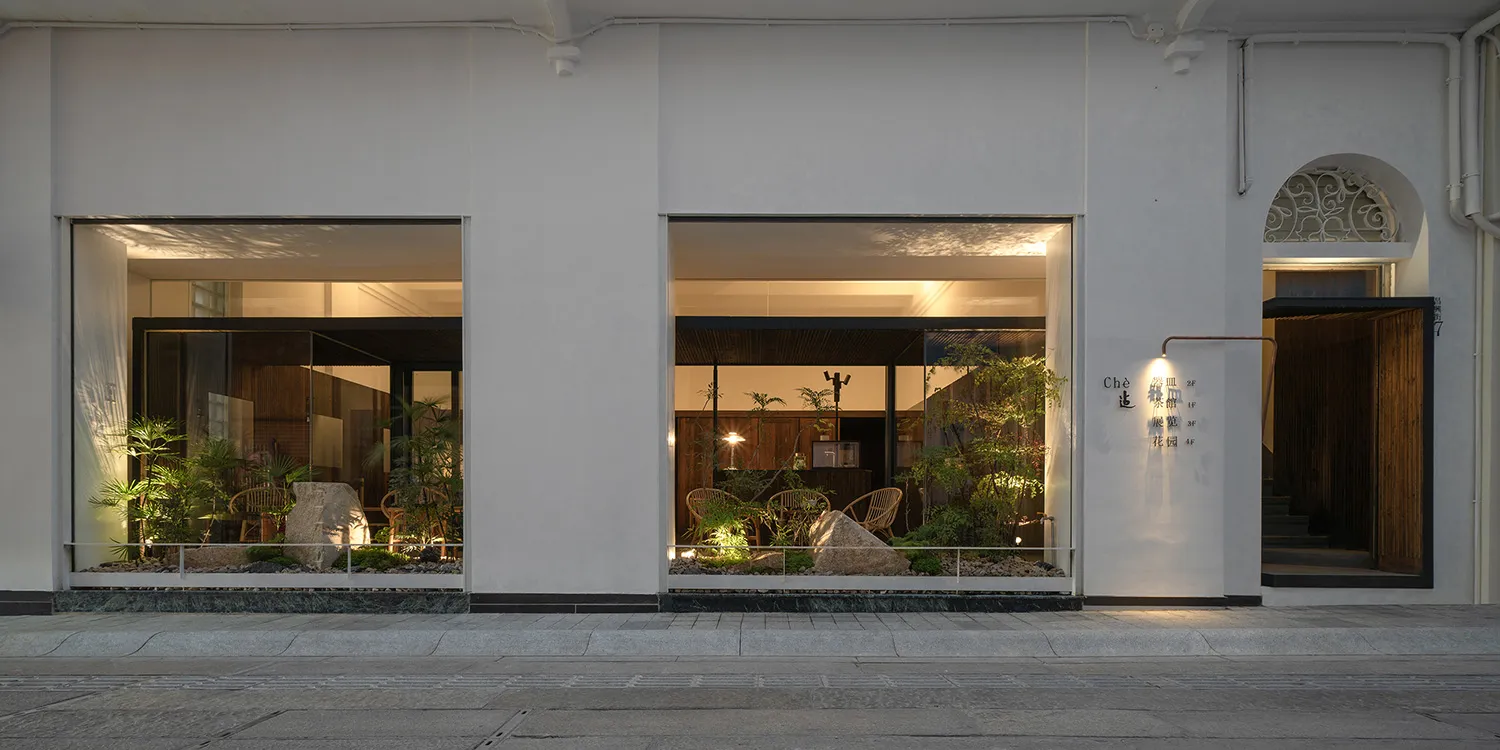 A modern retail storefront featuring a white marble exterior and a glass entrance.