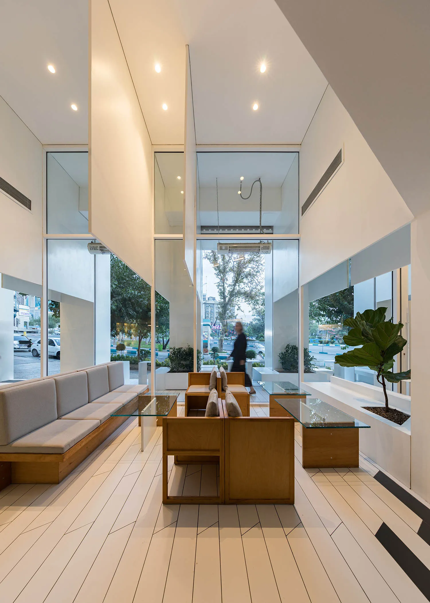 Modern restaurant interior with white concrete, wood, and glass elements.