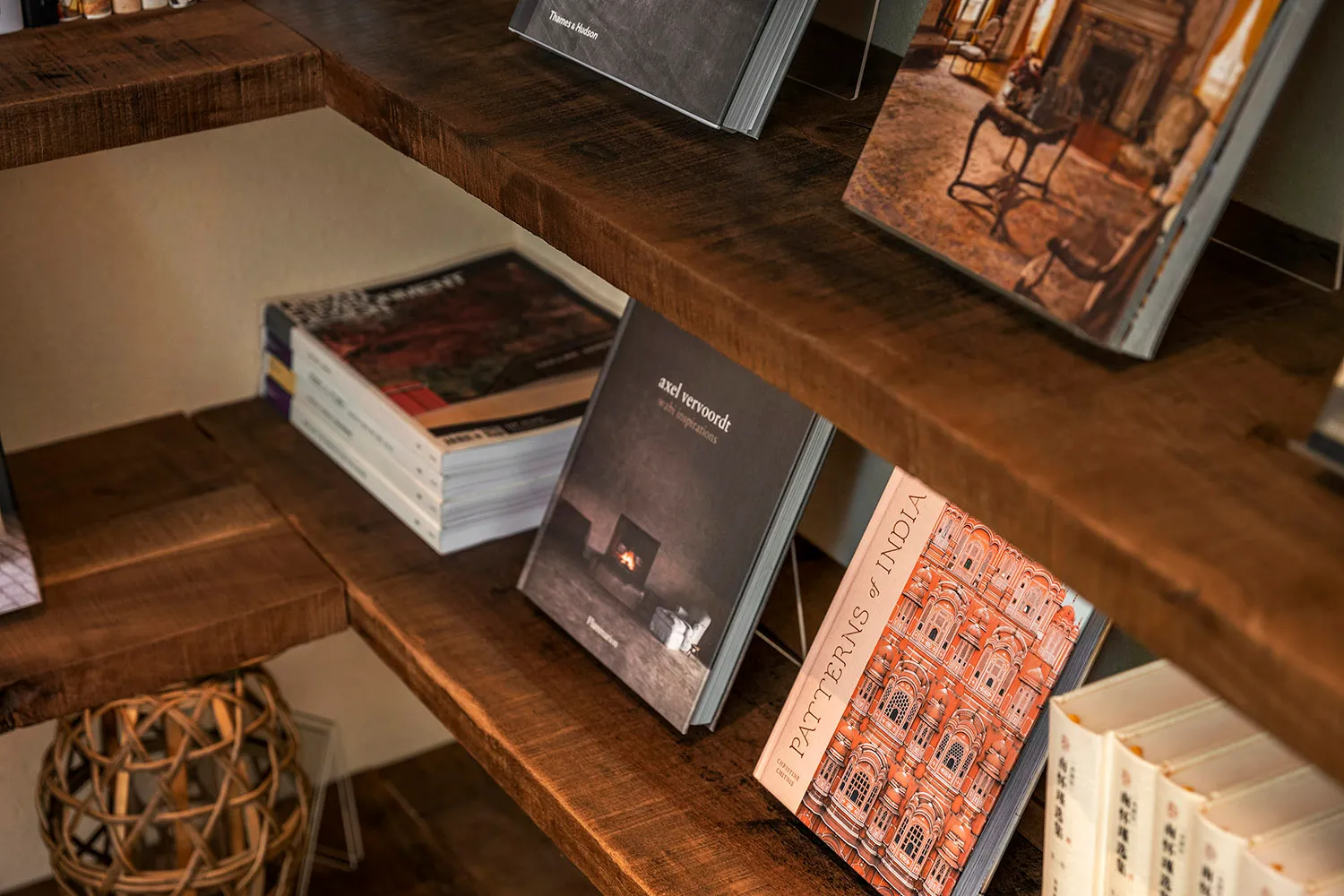 Books arranged on a wooden shelf, with various titles and subjects visible.