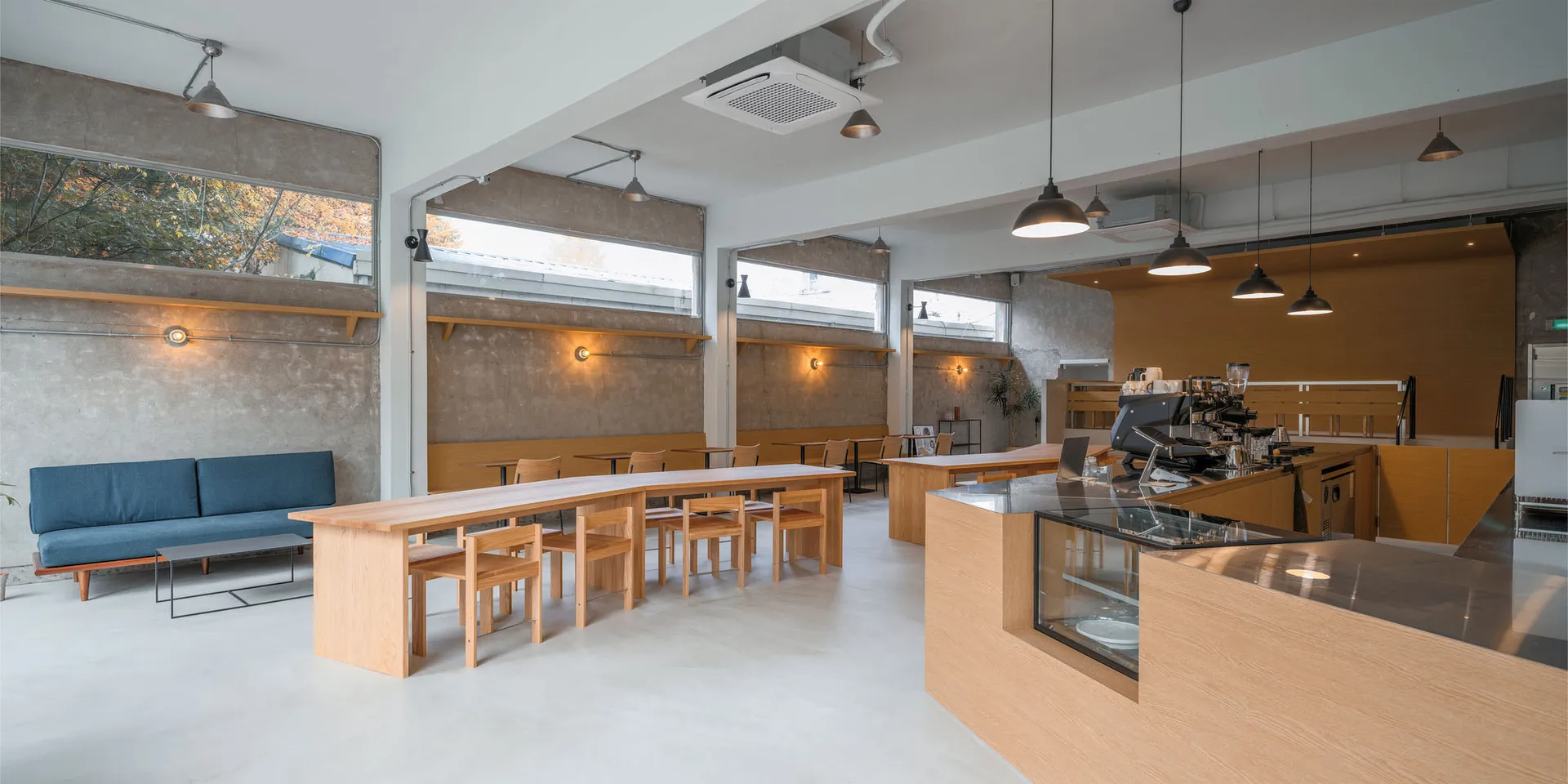 A minimalist coffee shop with wooden furniture and white walls.