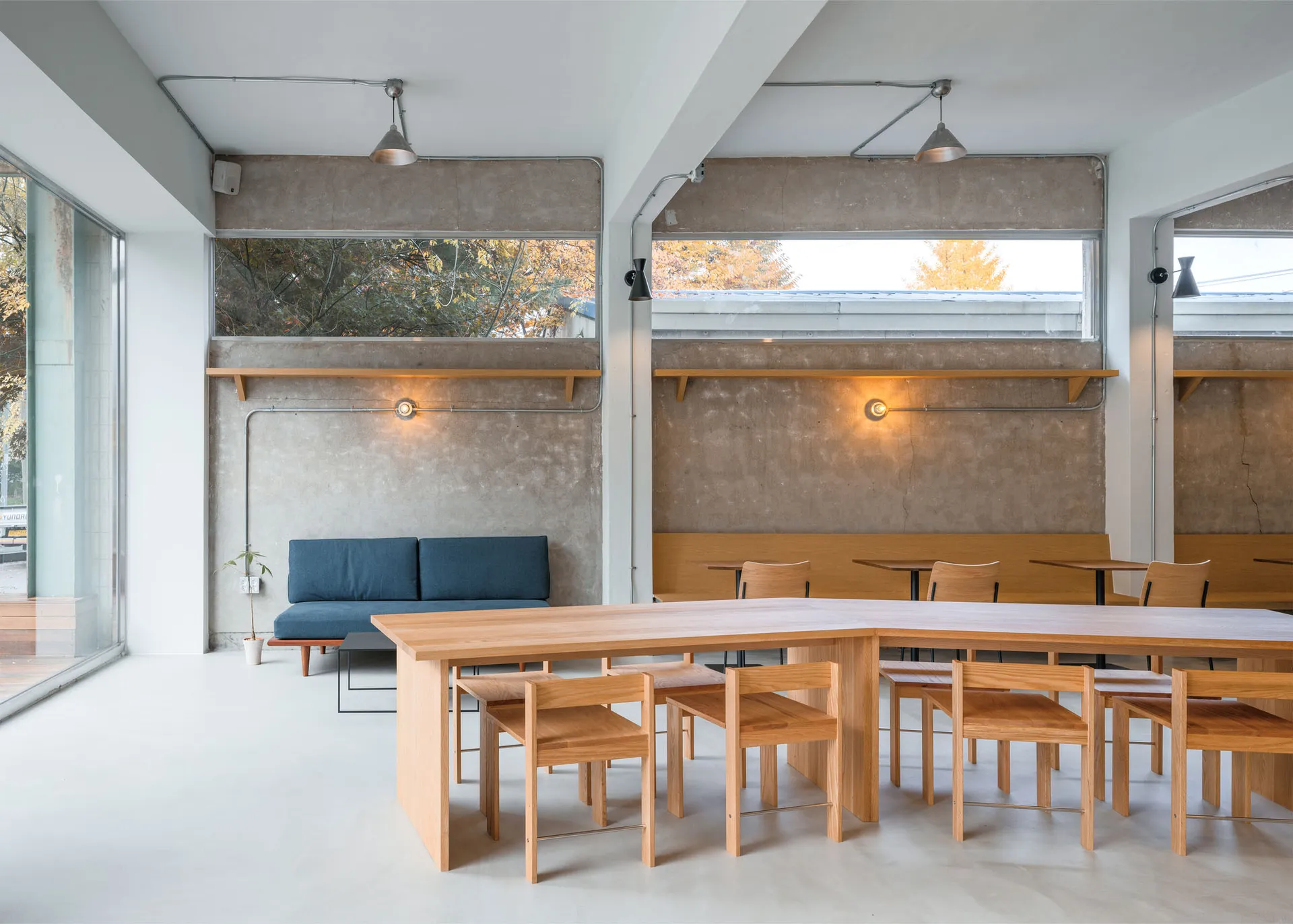 現代咖啡廳室內,木質餐桌搭配混凝土牆面