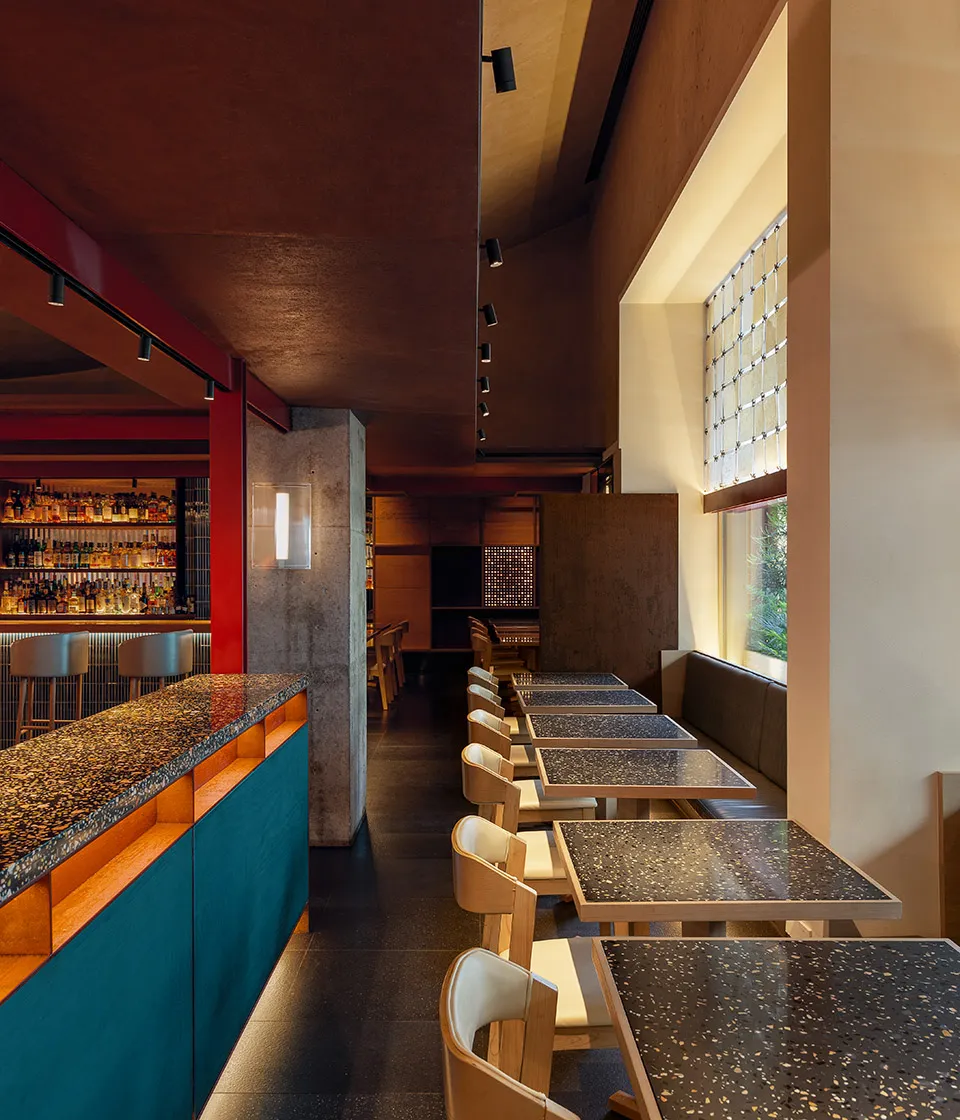 Industrial-style restaurant interior featuring terrazzo countertops and seating areas.