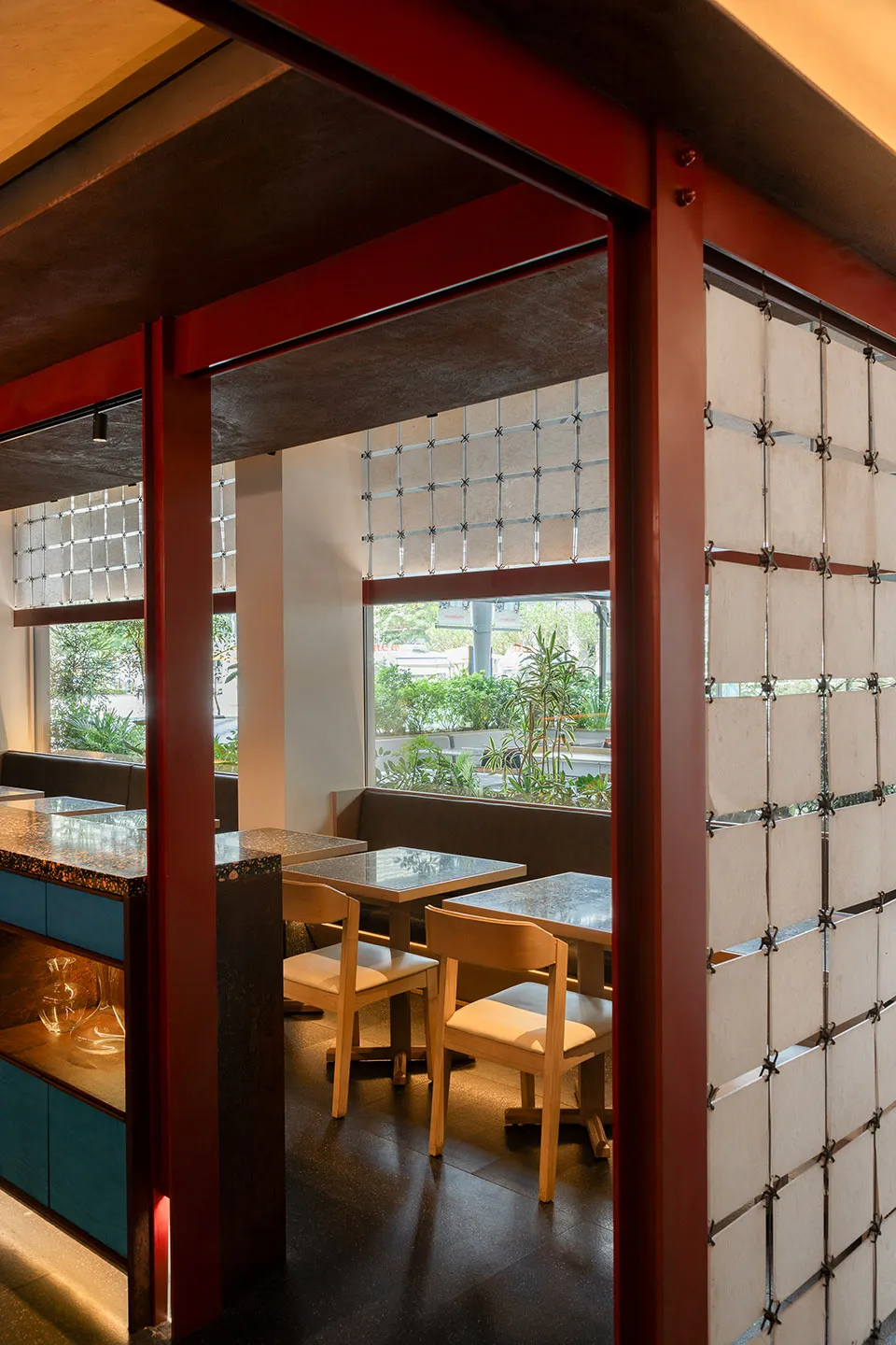 現代餐廳室內視圖,木質餐桌、混凝土牆面與玻璃隔間。