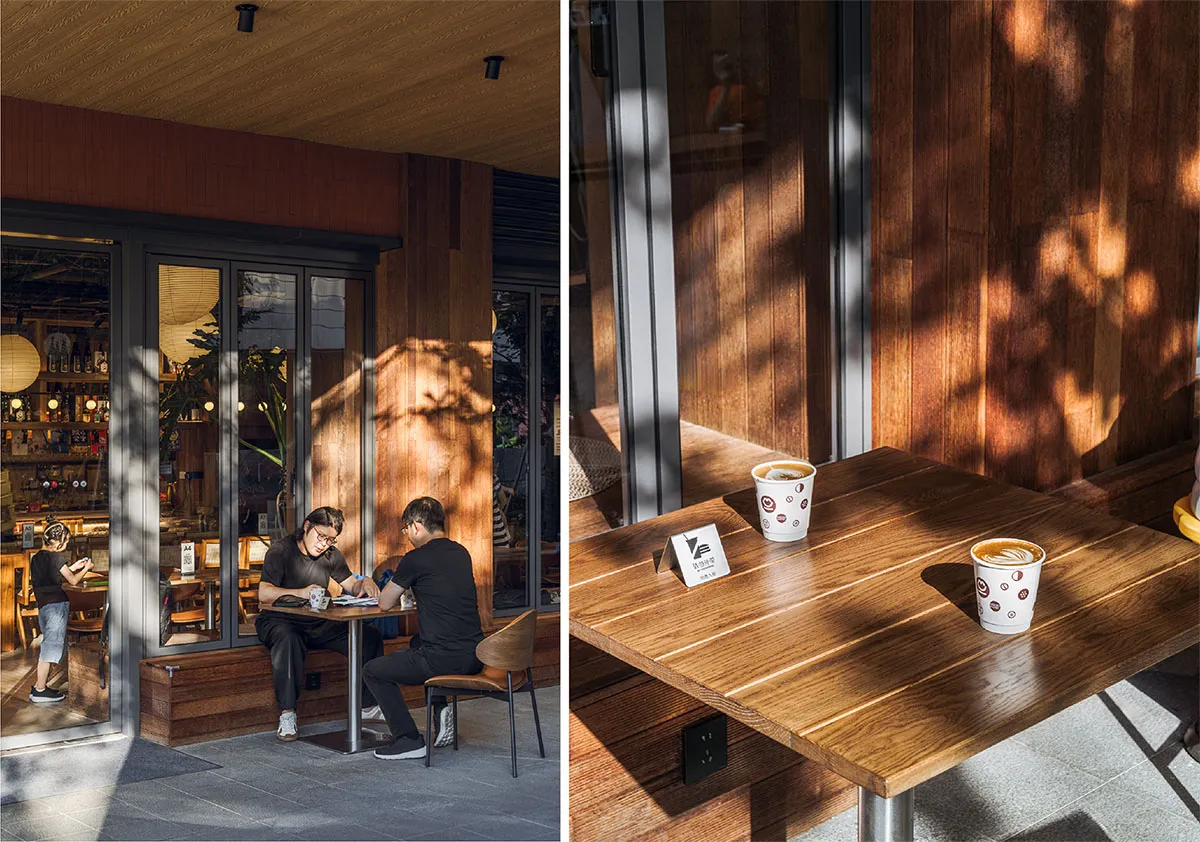People sitting at wooden tables in a coffee shop, with natural light filtering through the windows.