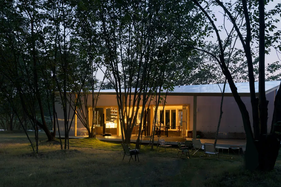 A modern minimalist residential exterior with glass and concrete materials.