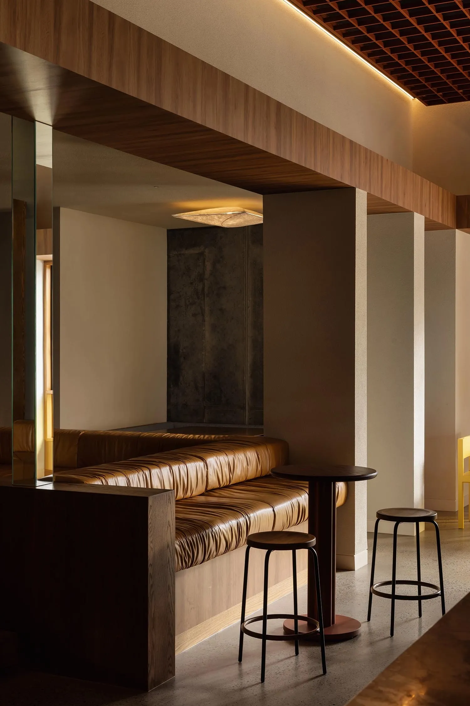 Modern restaurant bar interior with leather benches and wooden stools and ceiling beams