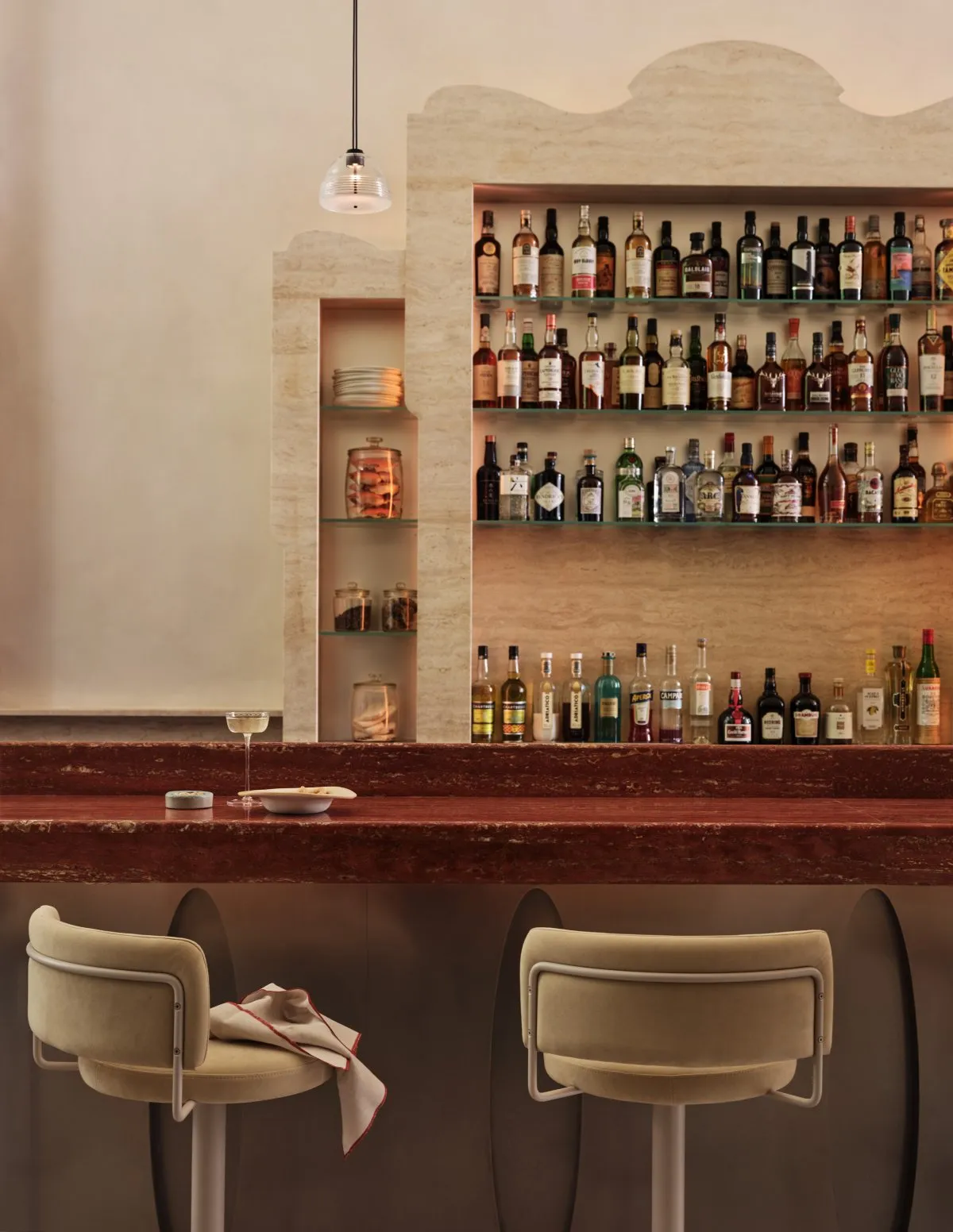 A stylish interior design featuring marble bar stools and a polished counter.