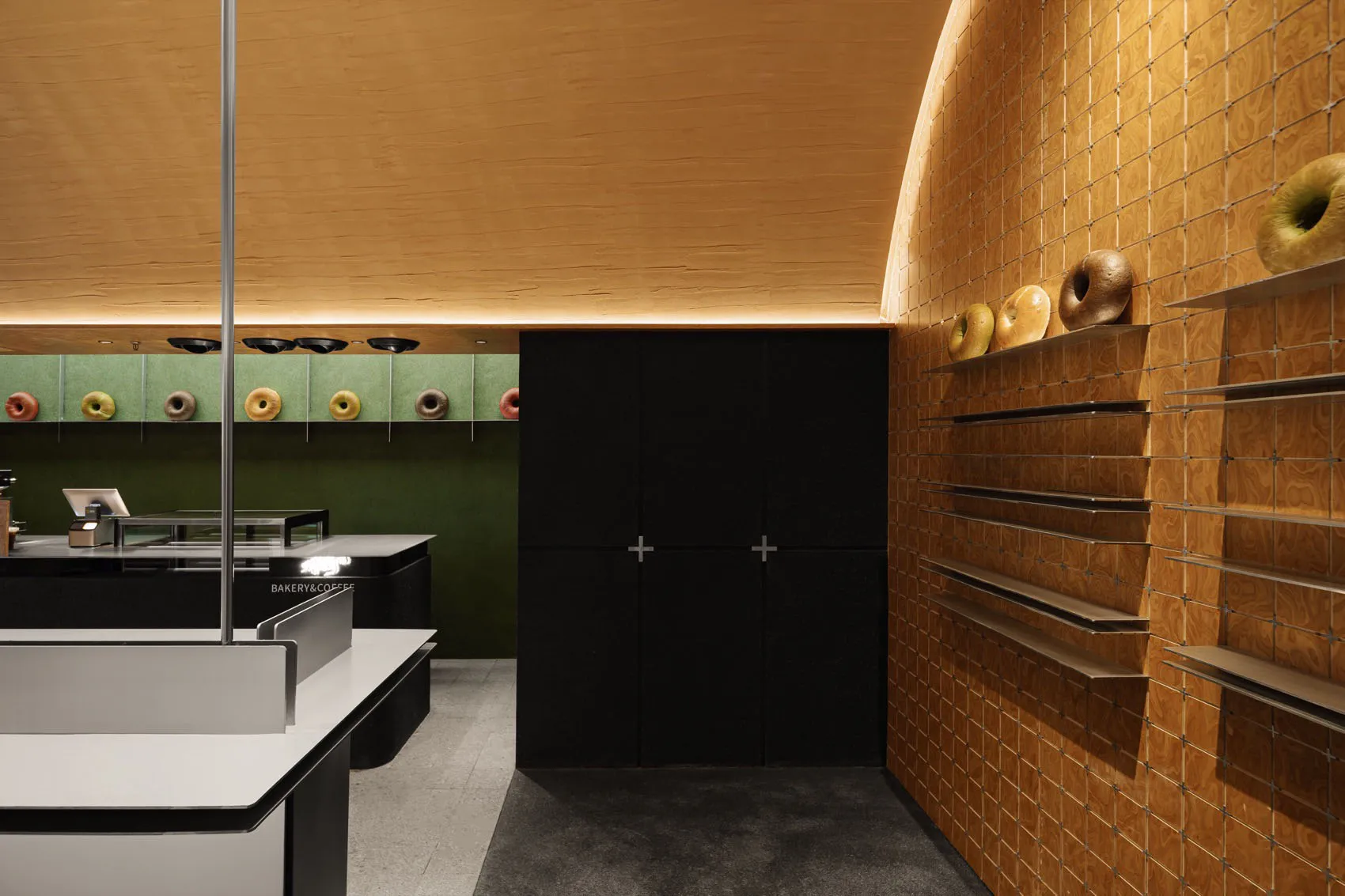 A modern bakery interior with wooden tiles and doughnuts on display.