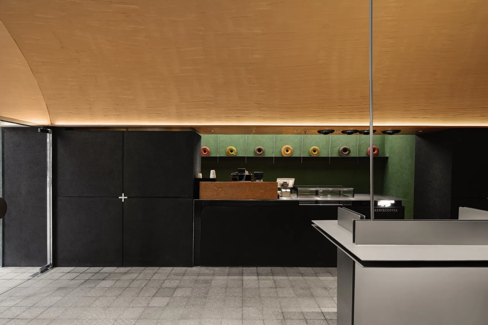 A minimalistic modern coffee shop featuring concrete and metal surfaces.