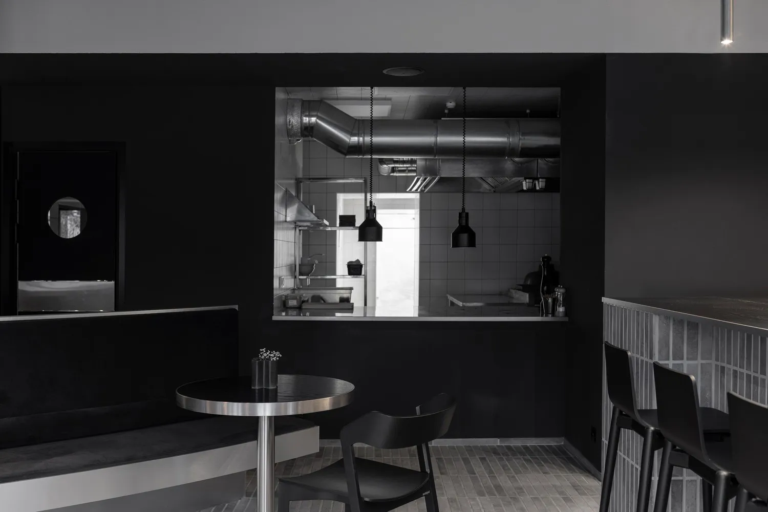 A minimalist restaurant interior featuring a black and metal design.