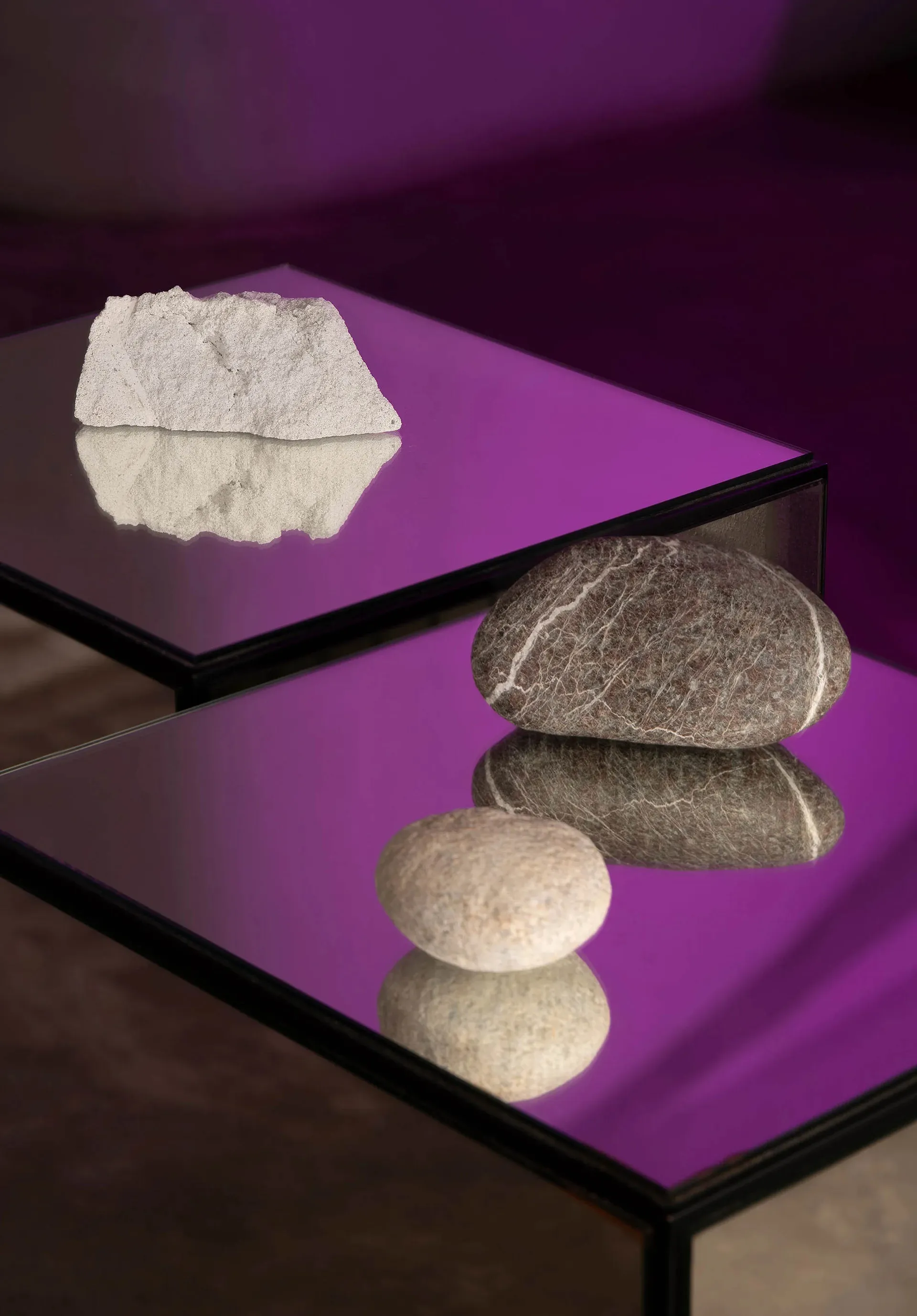 A modern glass table with decorative stones placed on it, creating a balanced and minimalist display.