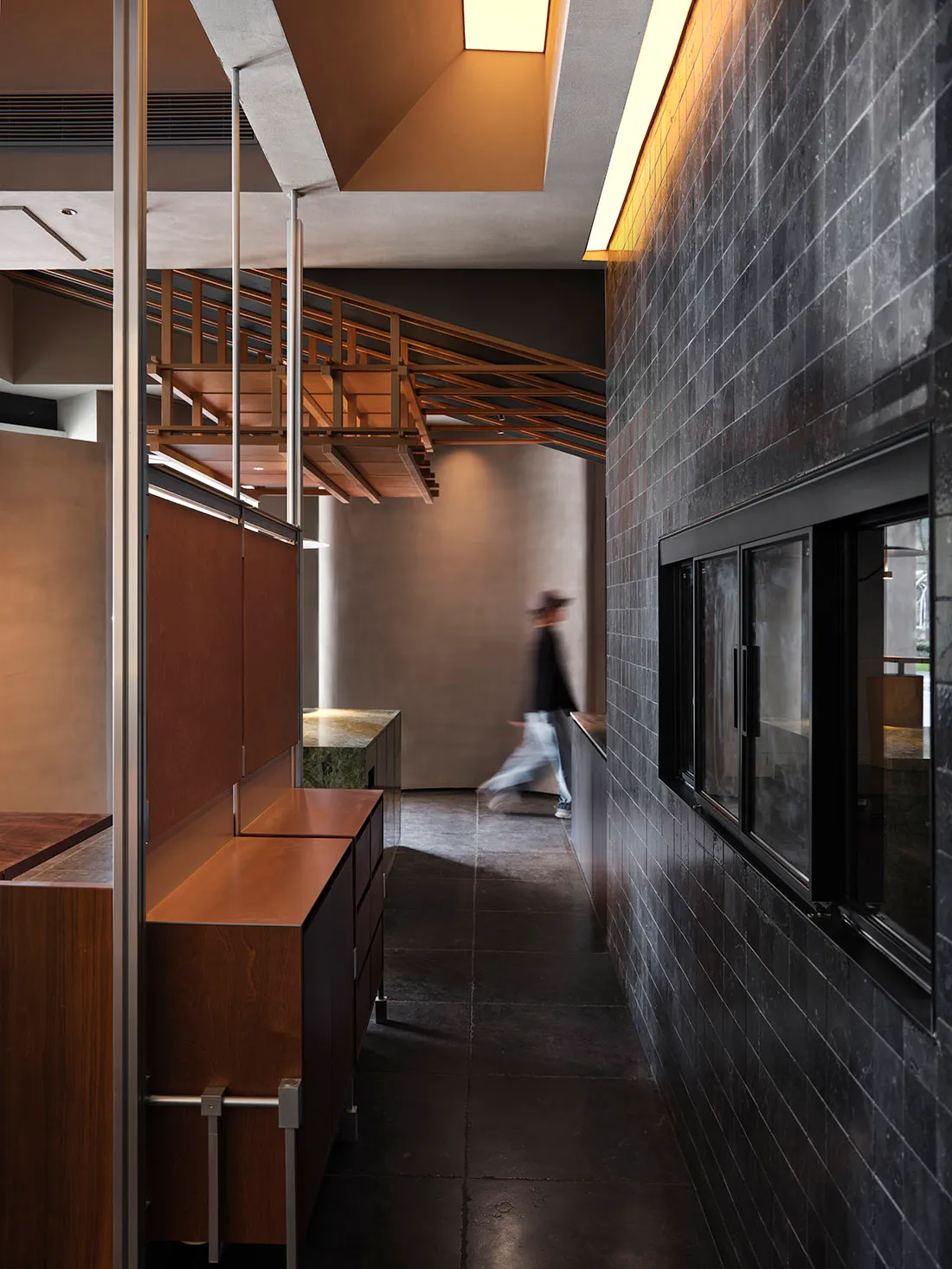Modern industrial hallway featuring minimalist design with concrete and brick walls, wooden railings, and sleek metal accents