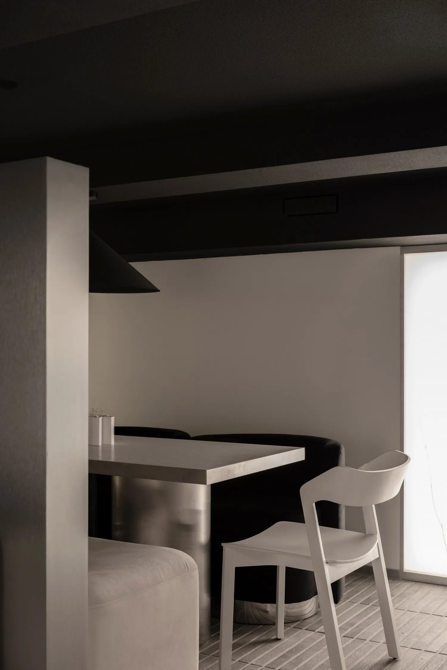 A minimalist modern restaurant setting featuring metal furniture and a sleek, clean aesthetic.