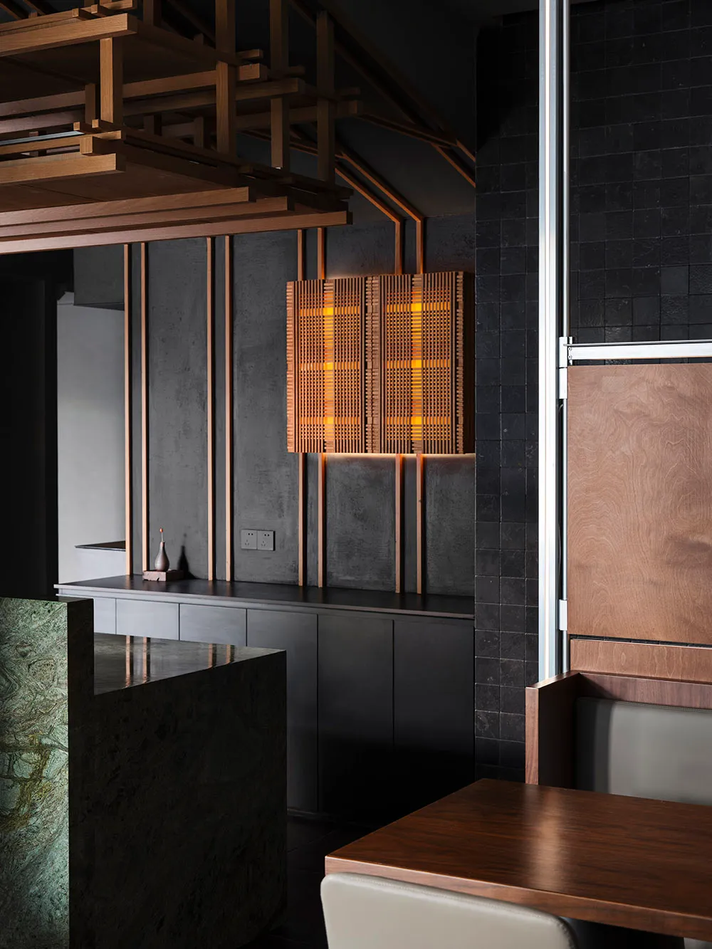 Modern minimalist restaurant interior featuring wooden accents, concrete walls, and metallic elements.