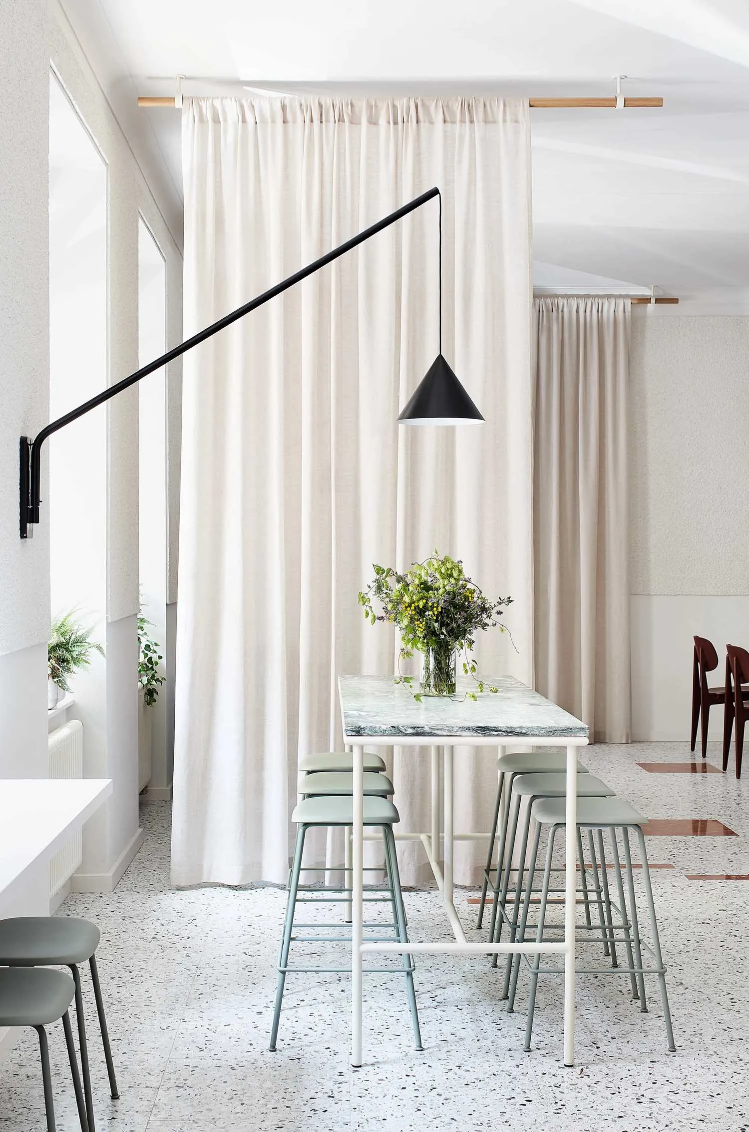 A modern kitchen with a marble table and stools.