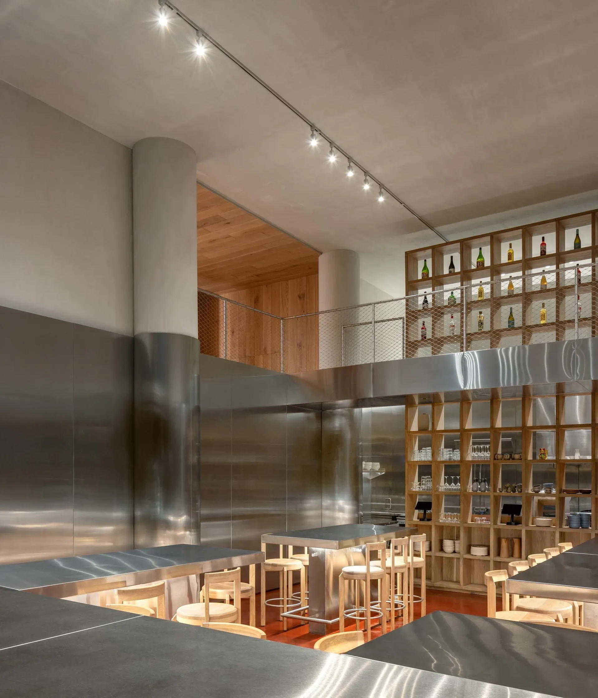Interior of a modern minimalist restaurant with metal walls and bar stools